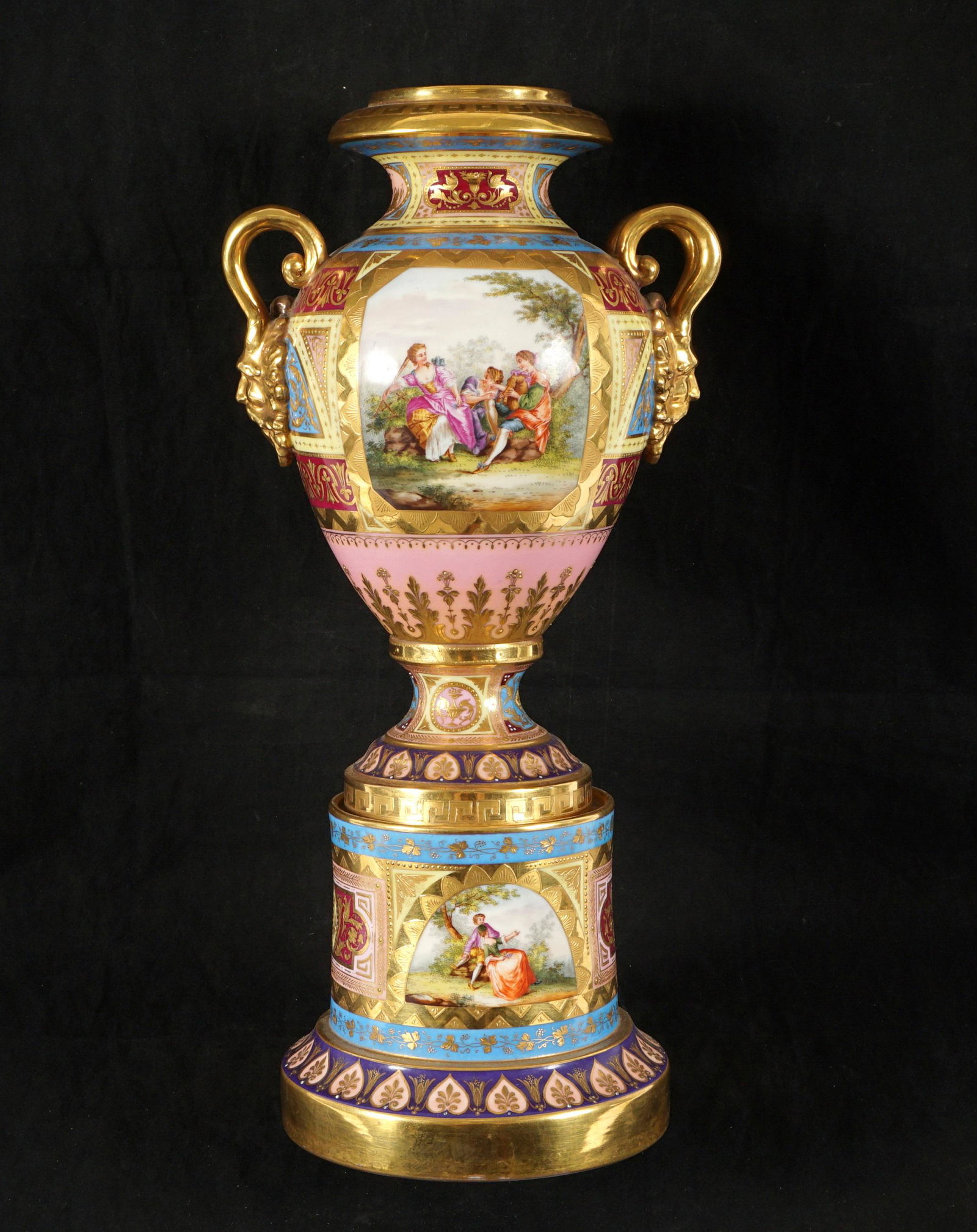 Royal Vienna Hand Painted Porcelain Urn: Gilt and hand painted panels with genre scenes in reserves, applied horned mask handles, marked under foot. Overall 15.75" h. x 7.5". From the estate of a prominent lawyer from New Rochelle, NY.