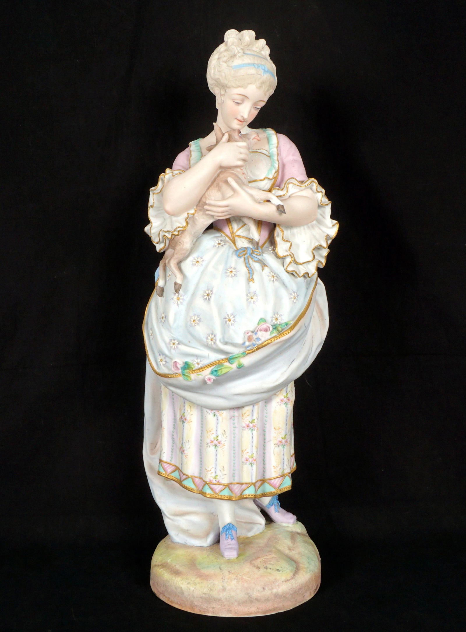 Bisque Figure of a Woman with a Lamb: Polychrome decorated figure of a woman with a lamb, dressed in finery, unmarked, overall 23" h. x 8".