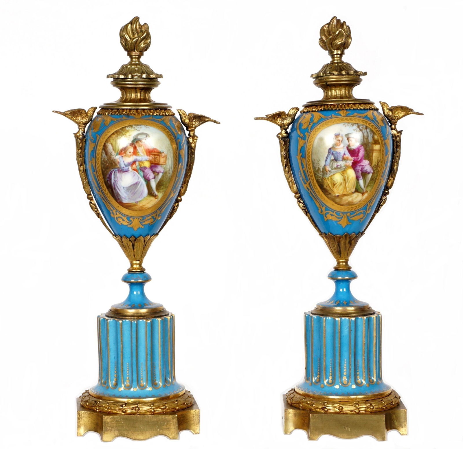 Sevres Style Porcelain Garniture Set: Pair turquoise ground with gilt accents, figural bird handles, hand paintse scenes of lovers and landscapes in reserves, on fluted pedestal base. Overall 13.5" h. x 5.5". From the estate of a prominen