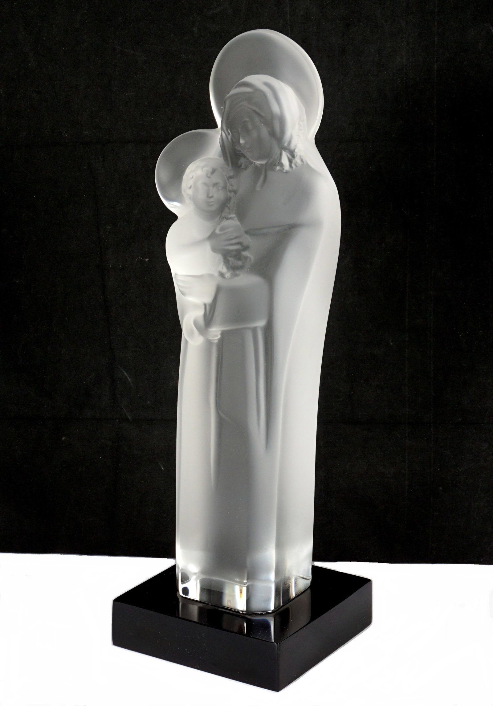 Lalique Crystal Mother and Child Figure: Molded frosted figure of the mother and child, on black base, Lalique sticker under base, overall 14.5" h. x 4.75" x 4.75". From the estate of a prominent lawyer from New Rochelle, NY.