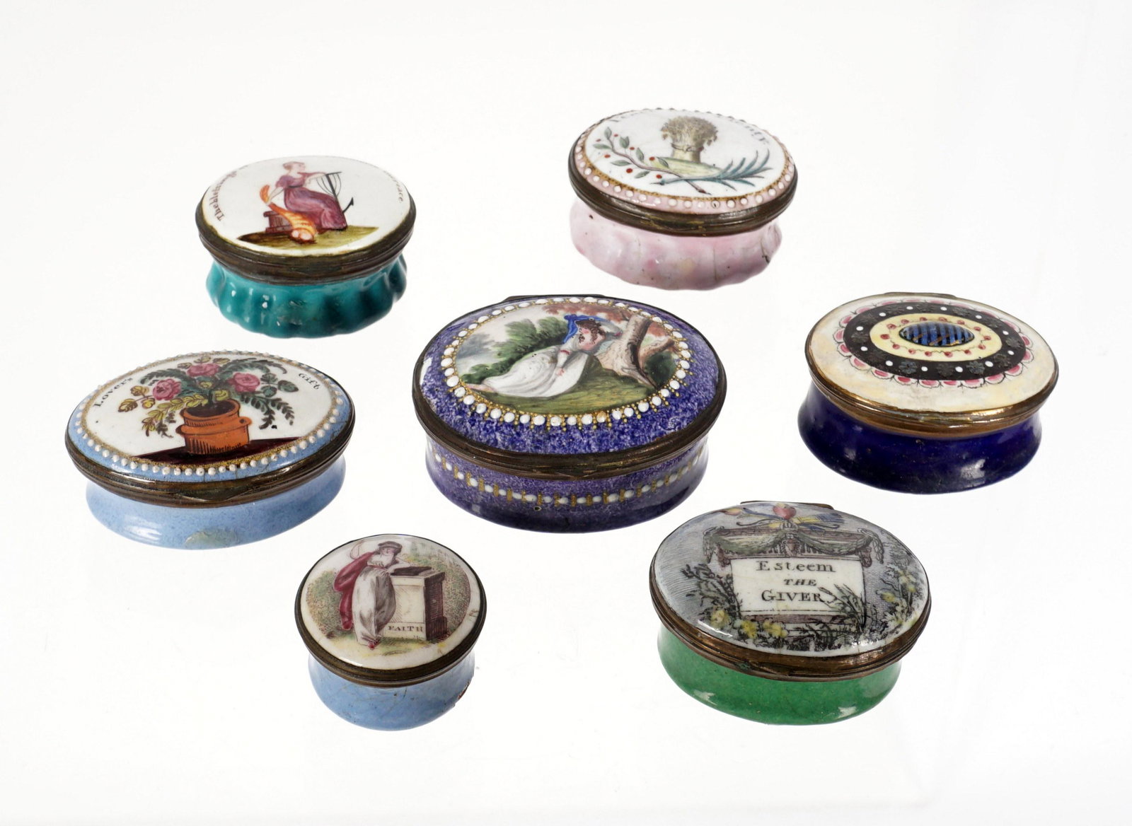 Seven Antique Bilston Enamel Patch / Snuff Boxes: An assembled collection of seven pieces total, each with assorted cover motifs, legends, quotes, and motto's. Largest oval with mirror interior lid measures 1" h. x 2" x 1.75". Smallest round .75" h.