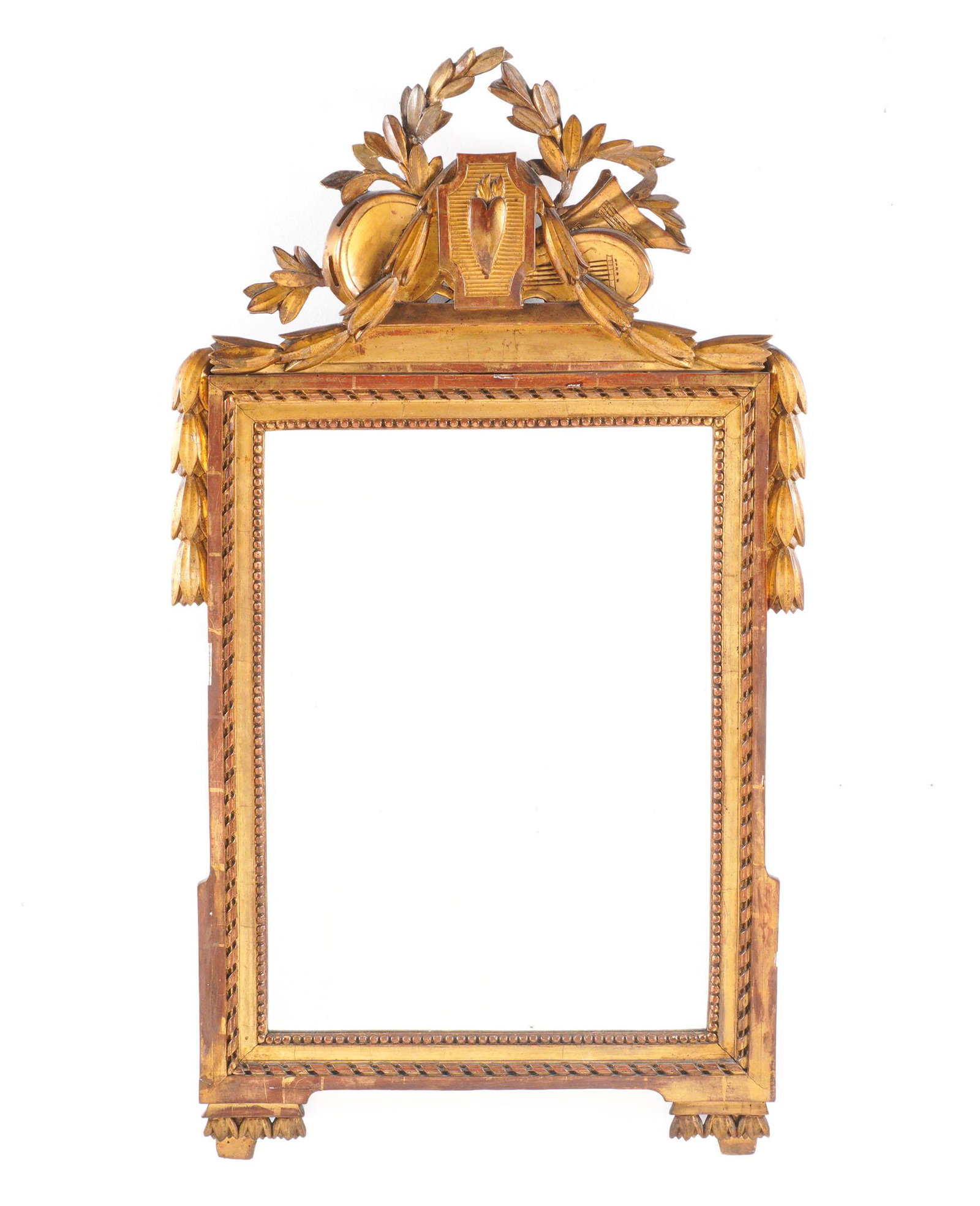 French Carved Giltwood Wall Mirror: Foliate crest with musical instruments, center flaming heart, trailing bellflowers. Inner rope twist and beaded bands, overall 44" h. x 25". Condition: Chips and wear to gilt.