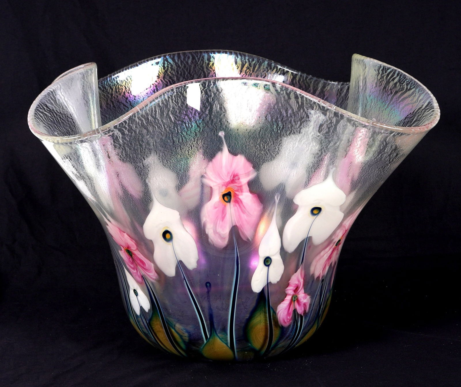 Monumental 2001 John Lotton Iridescent Glass Vase: Large iridescent clear glass body and rim with trillium type flowers raising from the base. Signed near base and dated 2001. Overall measures 13" h. x 21.25" dia. Please note white rectangles in photo