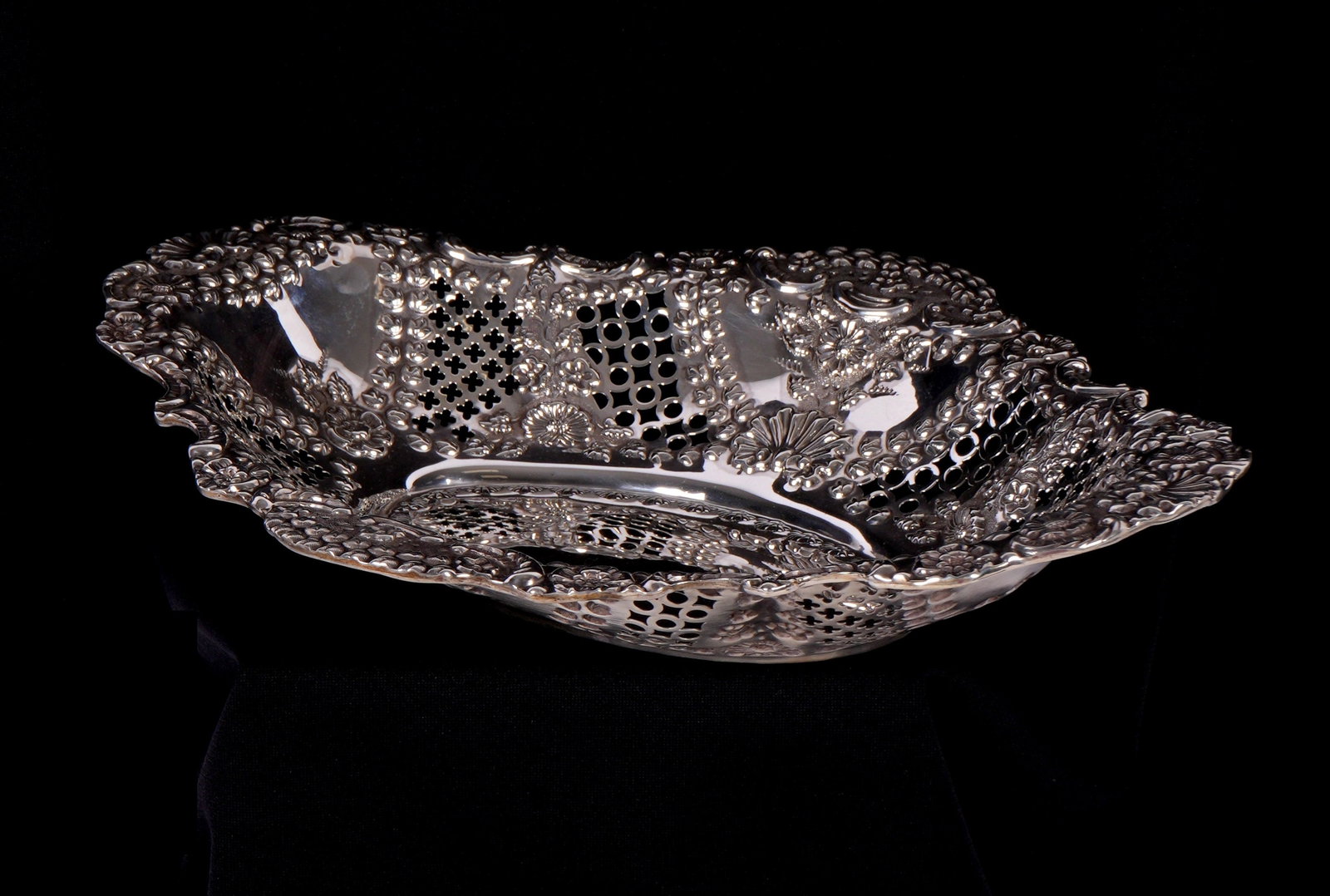 Williams English Silver Reticulated Bread Basket: Reticulate and embossed floral motif sides, well marked with Williams Ltd., Birmingham, and 1902 marks. Overall 2.25" h. x 12" x 9.5". Approx. 10.7 troy oz. Condition: Minor scratches.