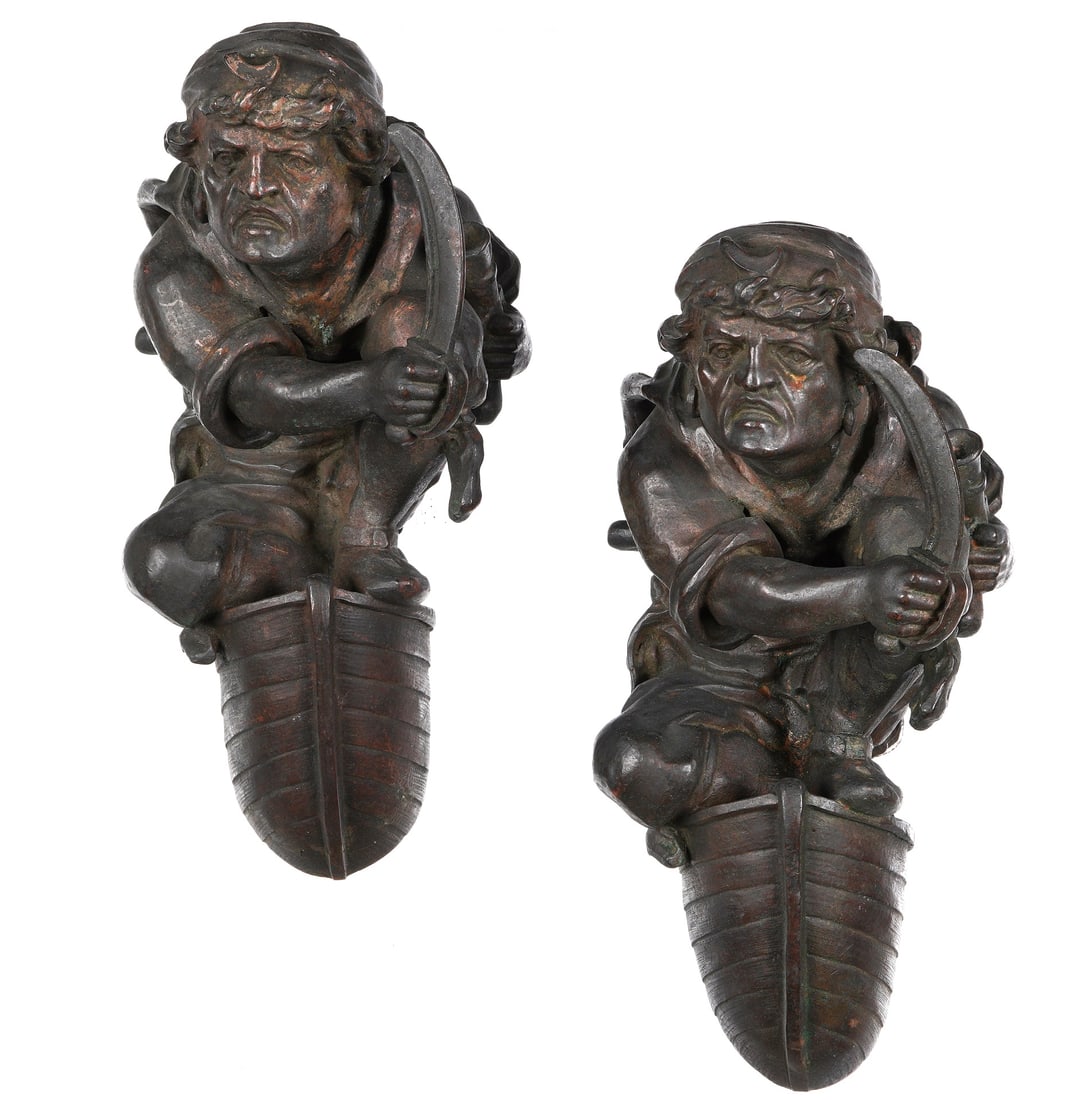 Pair Patinated Bronze Pirate Wall Sconces: Patinated bronze figural pirate holding a sword crouching at the bow of a boat, electrified single socket. No visible marking, overall 9.25" h. x 4.75" x 6.75". Condition: Uneven patina, not tested fo