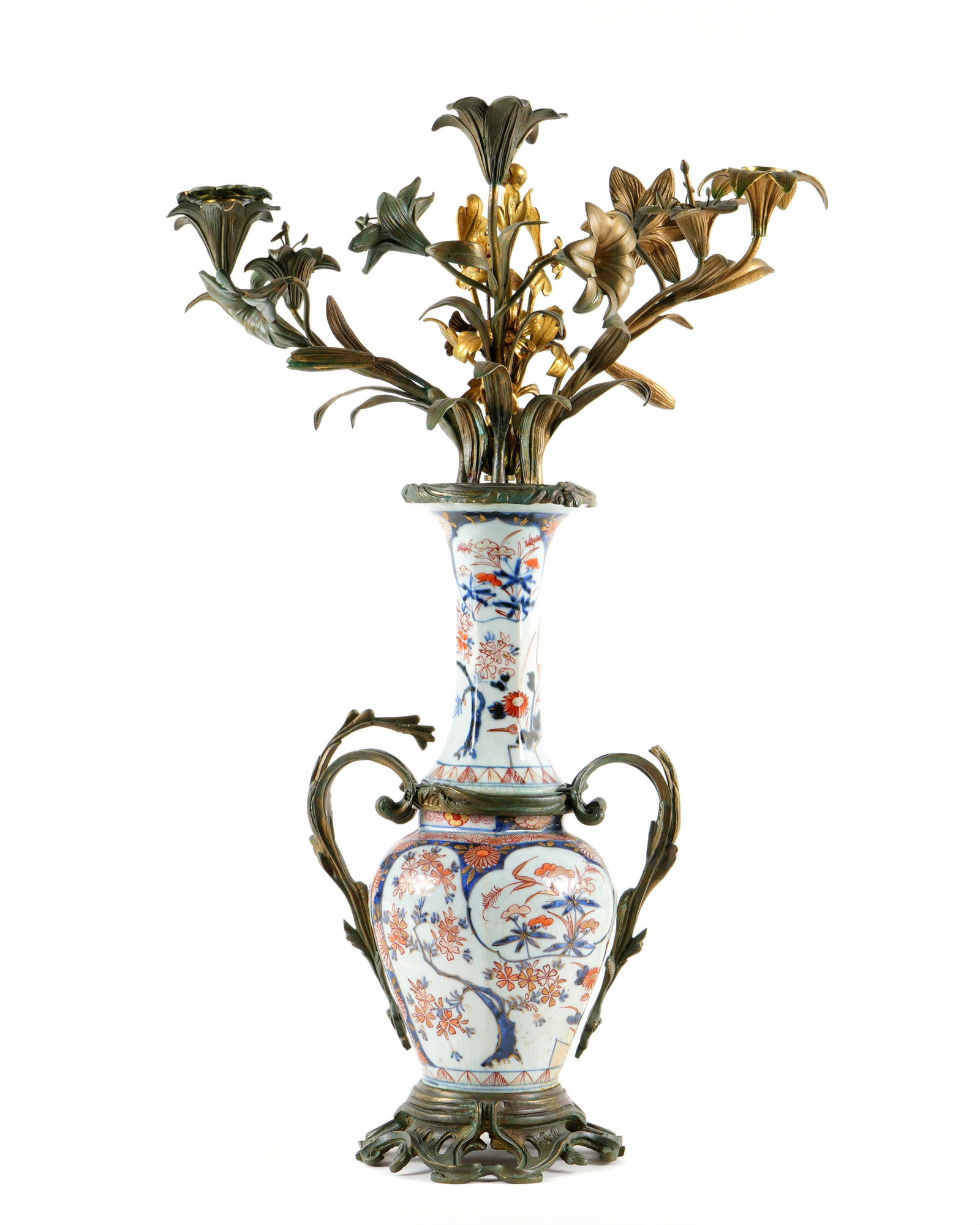 Chinese Bronze Mounted Porcelain Candelabrum: Porcelain decorated vase mounted with bronze handles, base, top with three floral scroll arms, center gilt bronze floral spray. Overall 22.75" h. x 15". Condition: Crazing, uneven finish to bronze.
