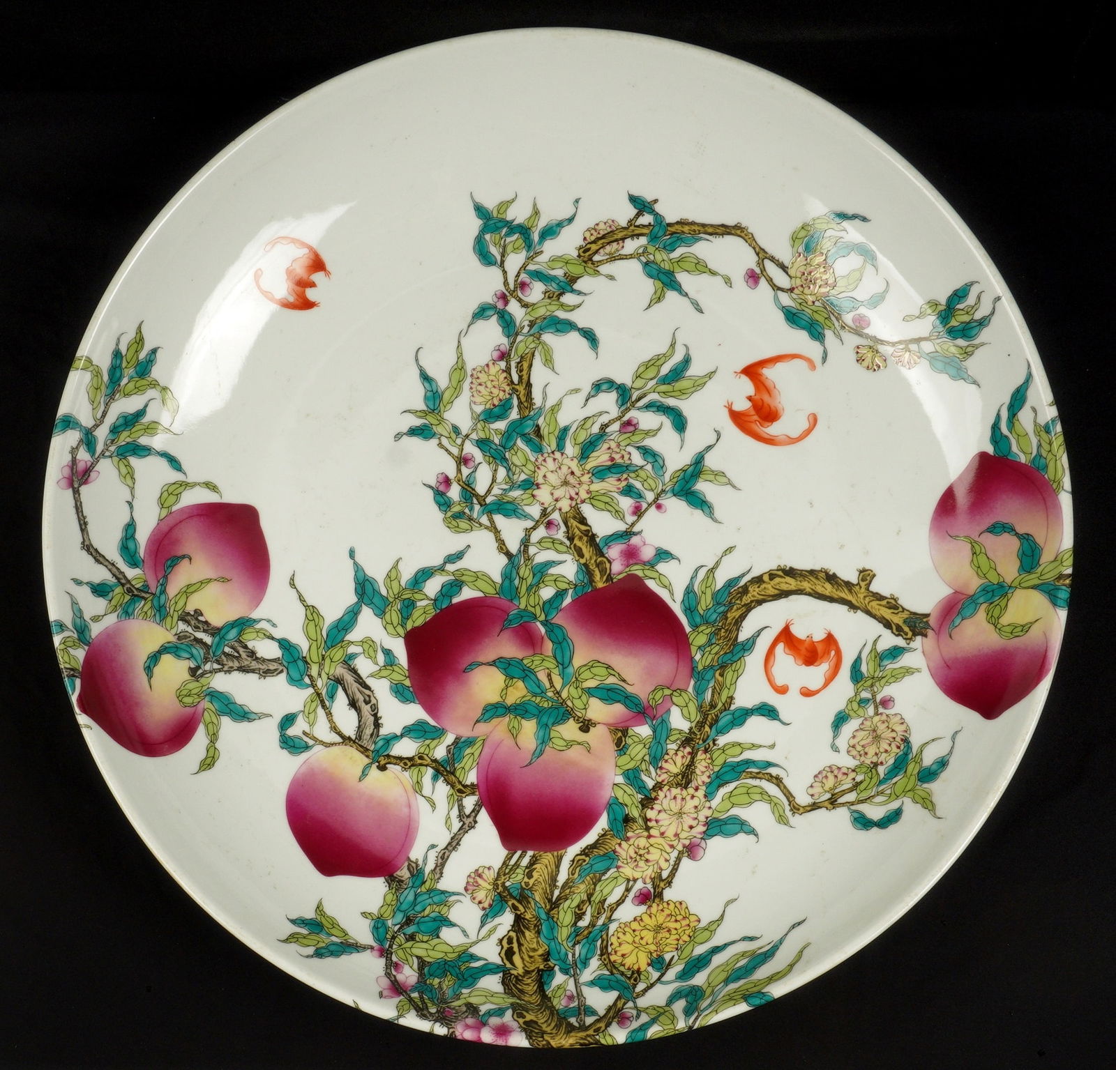 Large Chinese Famille Rose Porcelain Charger: Large charger with bats, peaches, blossoms and branches decoration on top and under rim, bears a six character Qianlong mark under foot. Overall 3.5" x 22" dia.