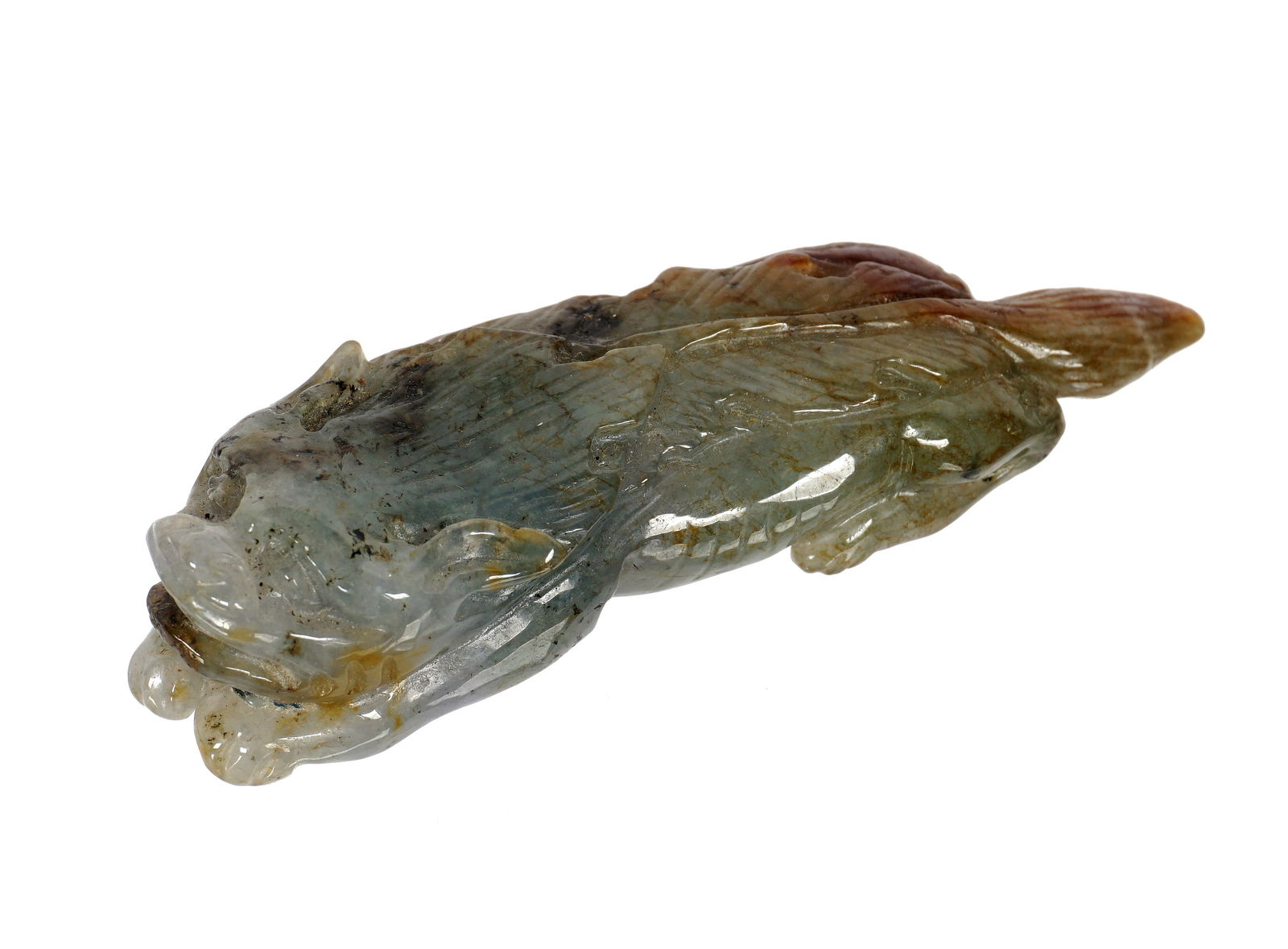 Chinese Carved Jadeite Recumbent Lion: Celadon, russet, and black jadeite carved figure of a recumbent lion, no evidence of impregnation, unsigned. Overall 1" h. x 4" x 1.25", 118 grams.