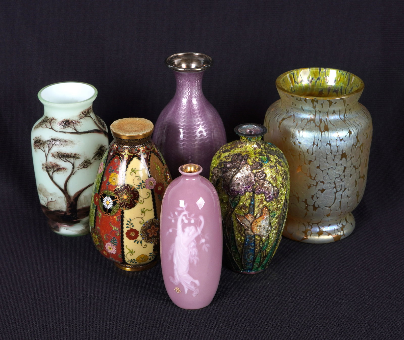 Worldly Collection of Six Vases: An assembled collection of six vases from all over the world to include continental oil sport iridescent glass vase, French cased glass with brown enamel landscape, purple guilloche over sterling balu