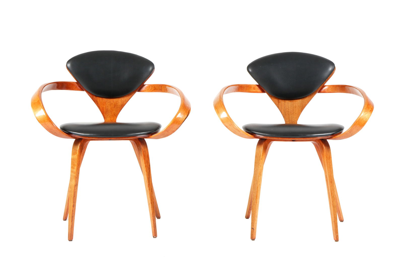 Two Norman Cherner for Plycraft Pretzel Arm Chairs: Pair lacquered and bent plywood "Pretzel" frames, black leather seats and backs. Measures 32" h. x 26.5" x 21.5". Wear consistent with age and use.