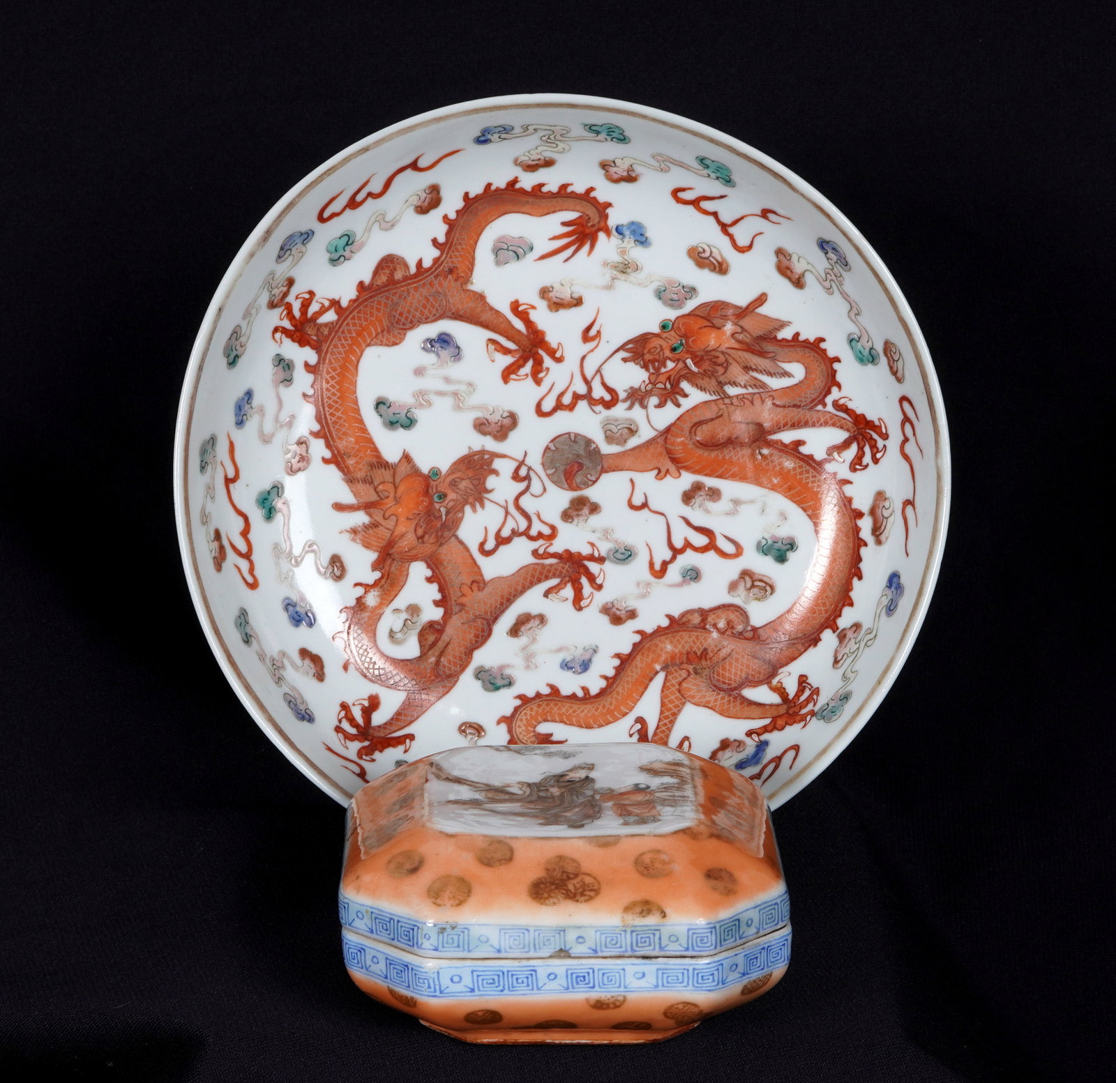 Two Piece Chinese Porcelain Covered Box and Dish: Two pieces total to include 1) Dragon motif low bowl / dish, bears six character Qianlong mark, 1.5" h. x 7". Condition: Chip and crack, wear to decoration. 2) Famille Rose covered square box, bears f