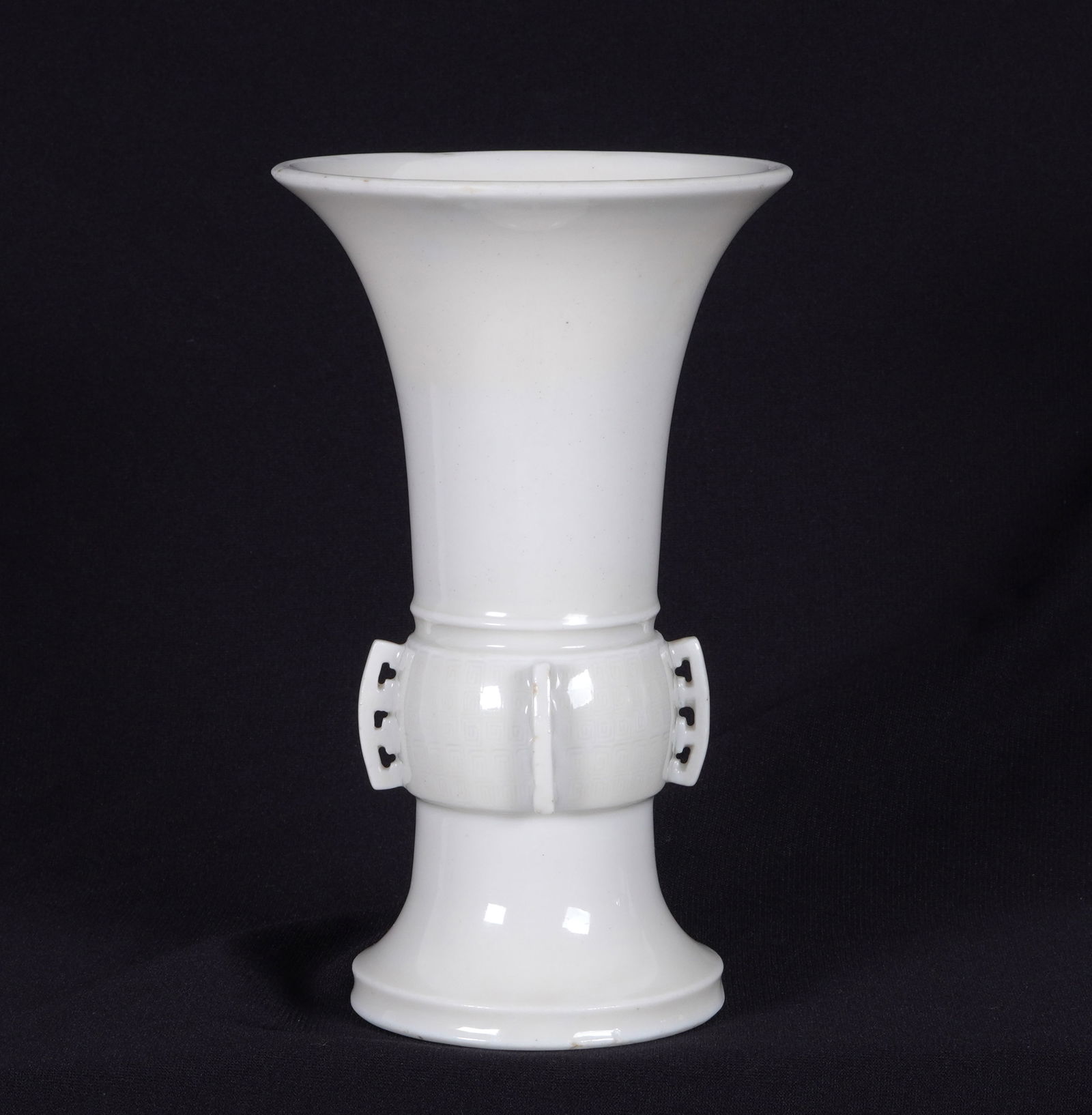 17th/18th Century Chinese Dehua Blanc de Chine Gu Form Beaker Vase: 17th/18th Century. Archaic style porcelain "Gu" form beaker vase, white blanc de chine glaze, unsigned, Overall 7.25" h. x 4.5" dia. Condition: Ground rim repair on upper rim. Repair to handle. Ex- So