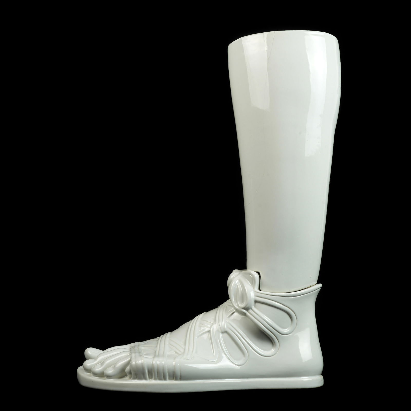 Large Fornasetti Ceramic Roman Umbrella Stand: White ceramic umbrella or stick stand modeled as a calf and left foot with Roman sandal, marked under foot. Overall 25.75" x 7.5" x 20". Condition: Cracks to top.