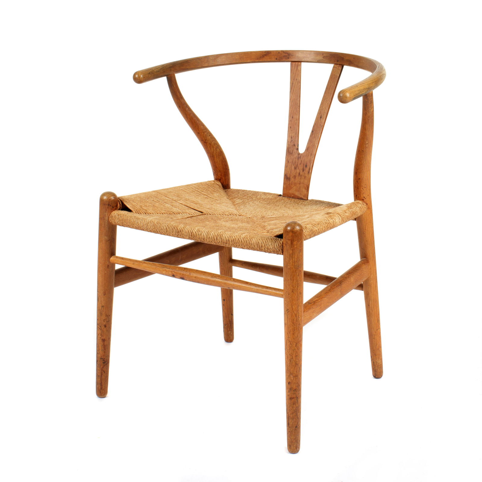 Hans Wegner for Carl Hansen & Son Wishbone Chair: Designed by Hans Wegner for Carl Hansen and Son Denmark, oak frame, rush seat. Well marked under seat on frame, 28.75" h. x 21.25" x 20.25. Condition: Wear to frame, stains and wear to seat.
