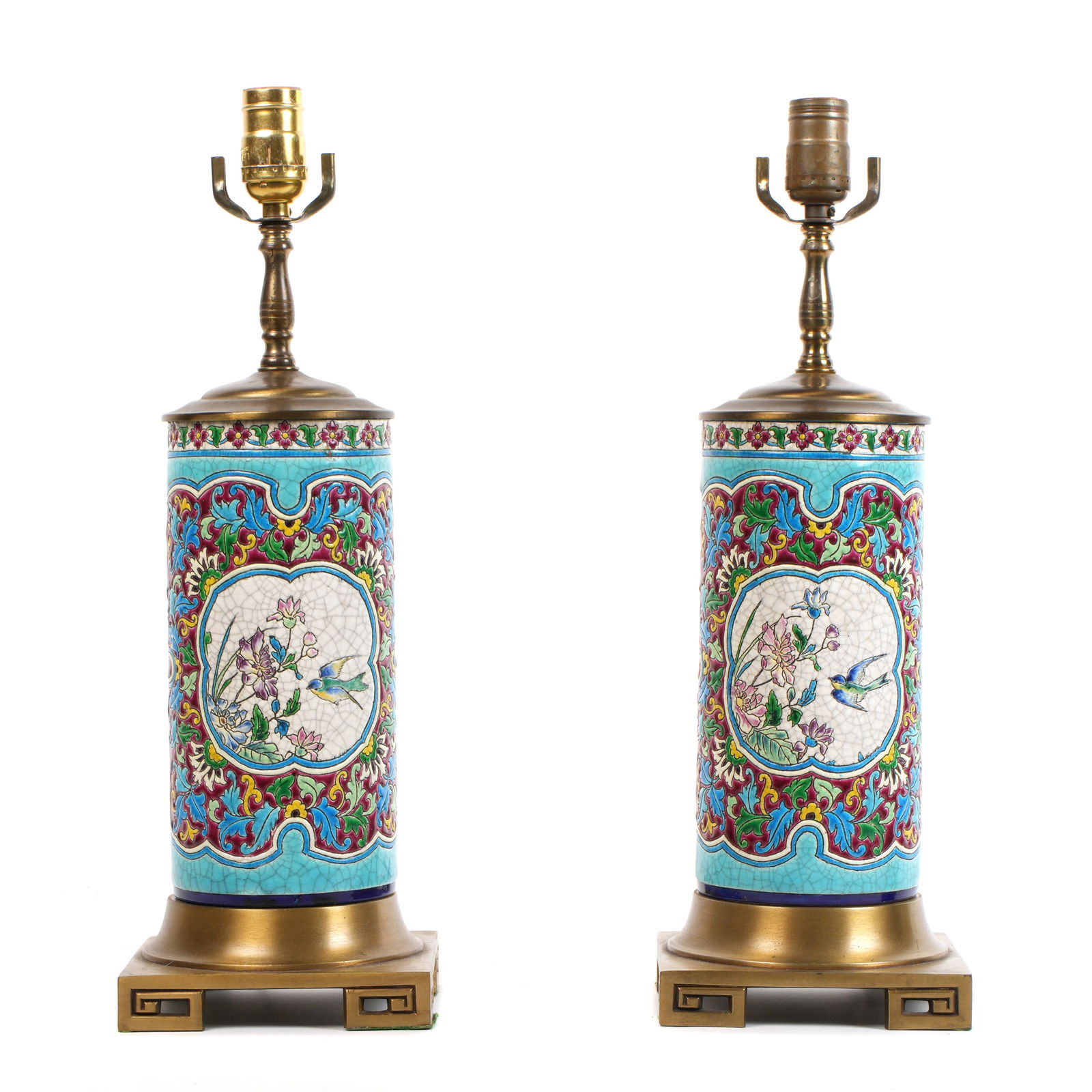 Pair Longwy Faience Porcelain Lamps: Polychrome faience foliate design, flowers, birds and butterflies in reserves, gilt metal bases, single socket fixtures. Overall 19" h. x 6.25" x 6.25". No shades or harps. Condition: Crazing. Metal w