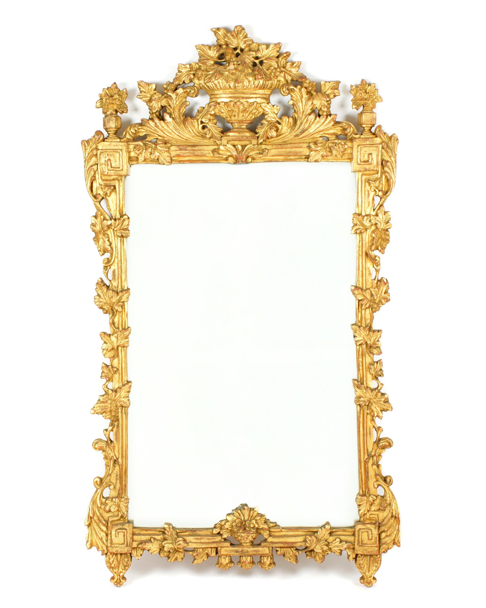 Italian Carved Giltwood Mirror: Flowering urn crest with trailing foliate vines on sides, lower flowering urn at base. Overall 55" h. x 31". Condition: Chip at top urn crest.