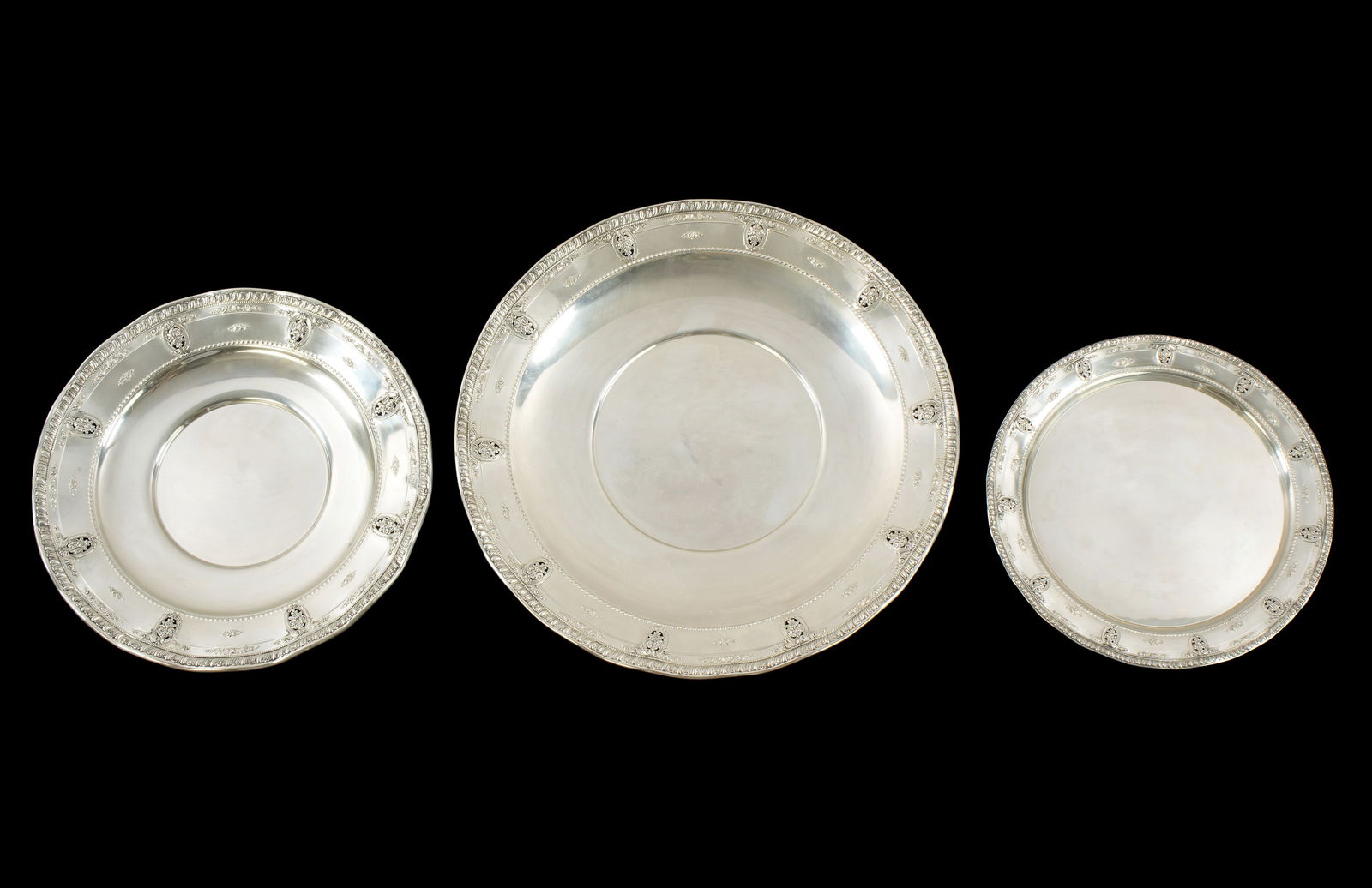 Three Wallace Rose Point Graduated Sterling Trays: A graduated set of three sterling silver trays in the "Rose Point" pattern by Wallace Silversmiths, trays measure 17.5" dia, 13.25" dia, and 12" dia. All well marked, approx. 62.8 troy oz. Condition: