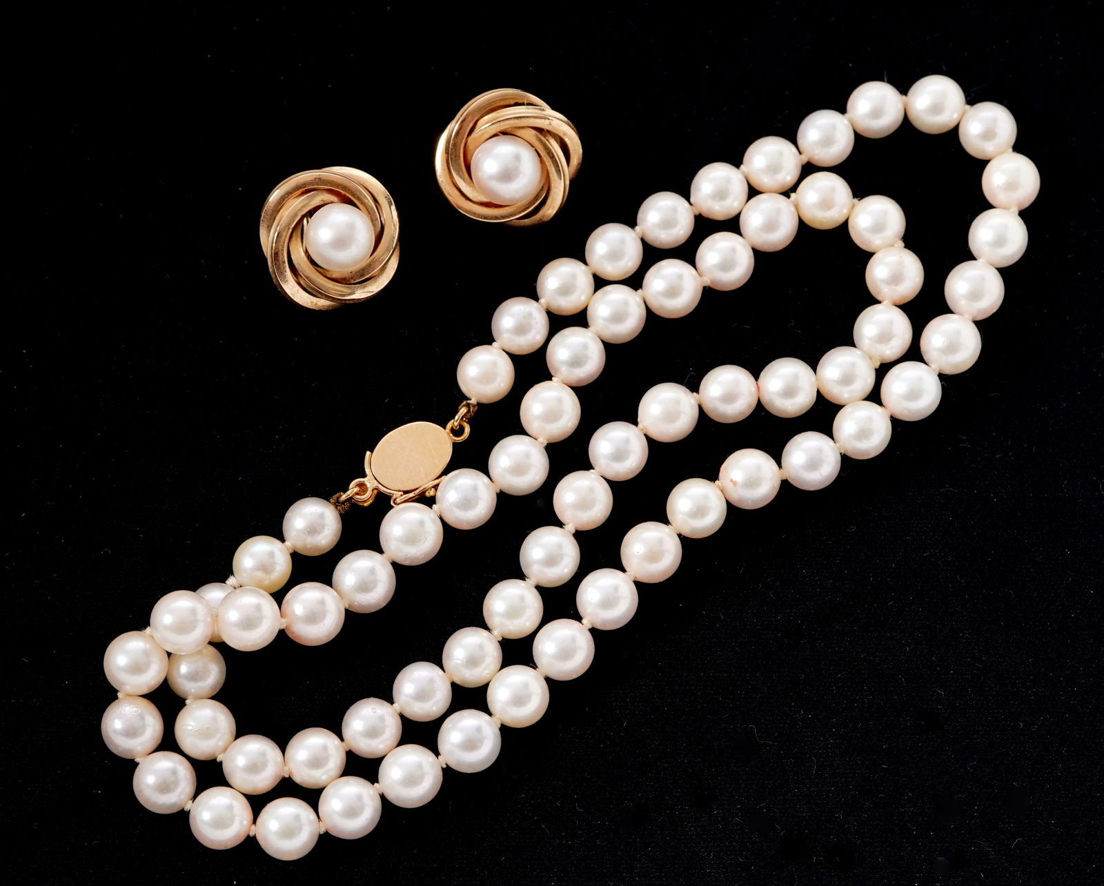 14k Gold Cultured Pearl Necklace & Earclips: 14k yellow gold clasp string of pearls necklace, pearls approx. 5mm dia. Sold with pair of ribbon earclips, center approx. 6 mm pearl. Necklace 18.25" long.