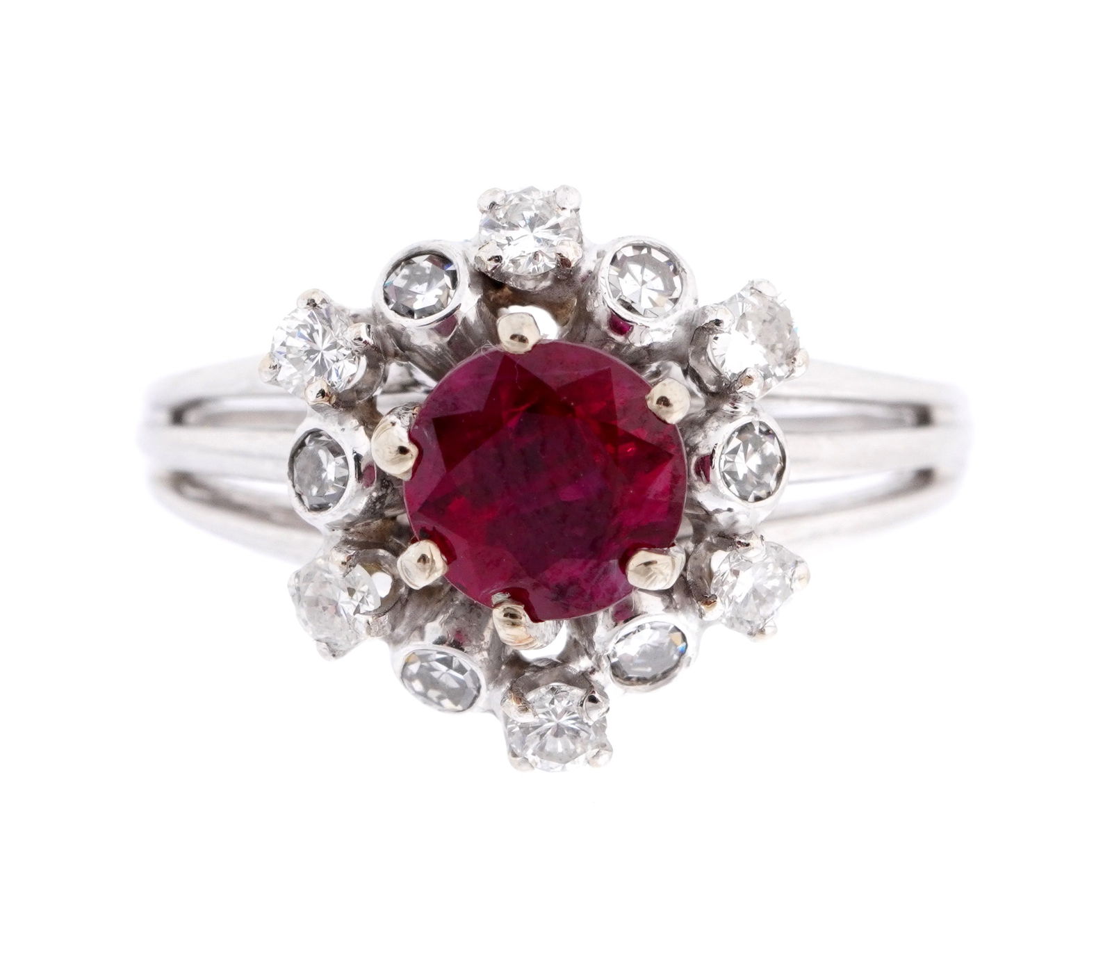 14k White Gold Ruby and Diamond Ring: 14k white gold band, center round cut prong set ruby approx. .75ct. above twelve round cut alternating bezel and prong set diamonds, approx. 1.2 ctw. Size 5. Approx. 3 grams inclusive.