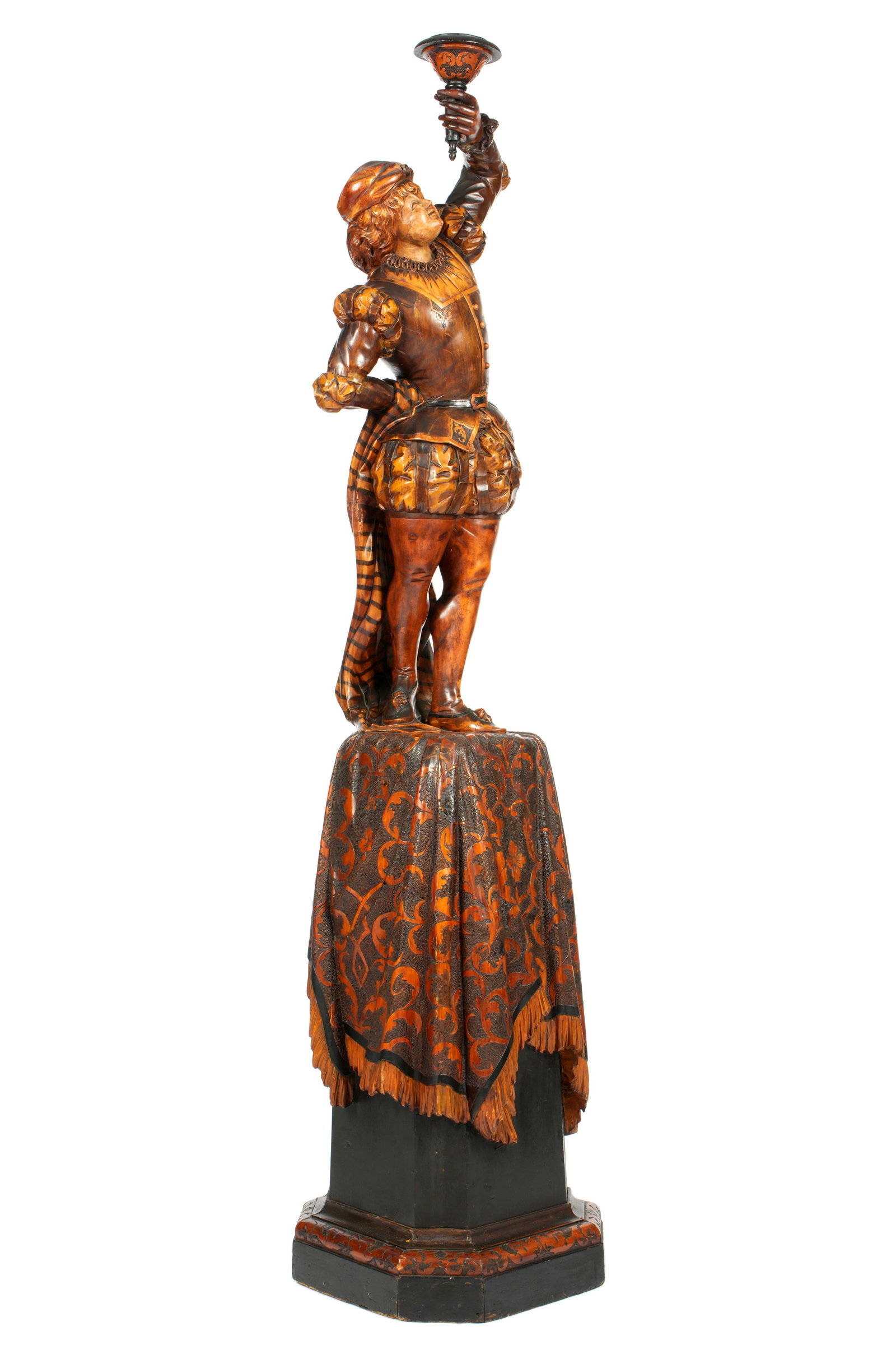 Manner of Besarel Carved Wood Page Boy Sculpture: Manner of Valentino Besarel carved and wood figure of a page boy holding a torchiere aloft in left hand. Affixed to ornately carved and painted tapestry design base, no visible signature or markings.