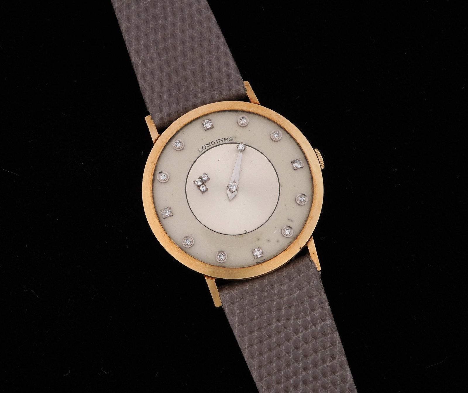 Longines 14k Gold & Diamond Mystery Dial Watch: Longines "Mystery Dial" manual wind wrist watch, 32mm 14k yellow gold case, mixed dial with accent diamond markers, lizard band, 8.5" long. Condition: Minor wear to case, spotting to dial. Currently r