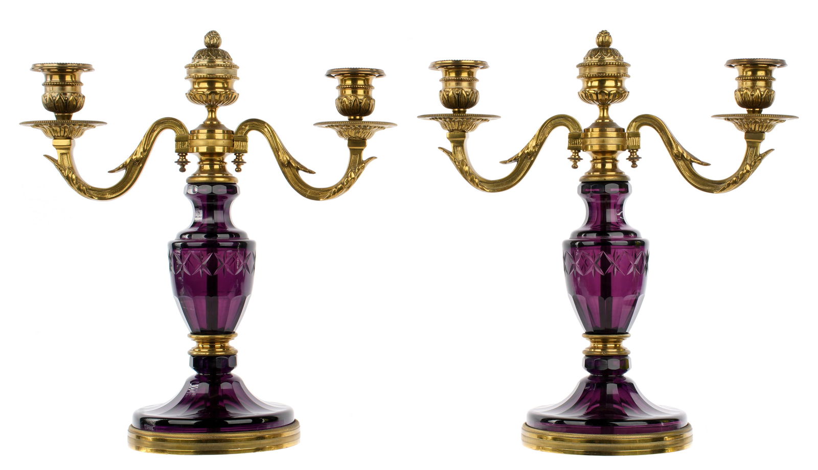 Pair French Bronze Dore Amethyst Glass Candelabra: Two gilt bronze foliate scroll arms, center light with removable snuffer. Faceted and cut amethyst glass body, marked "Made in France" under foot. Overall 12" h. x 11" x 5". Condition: One center bobe