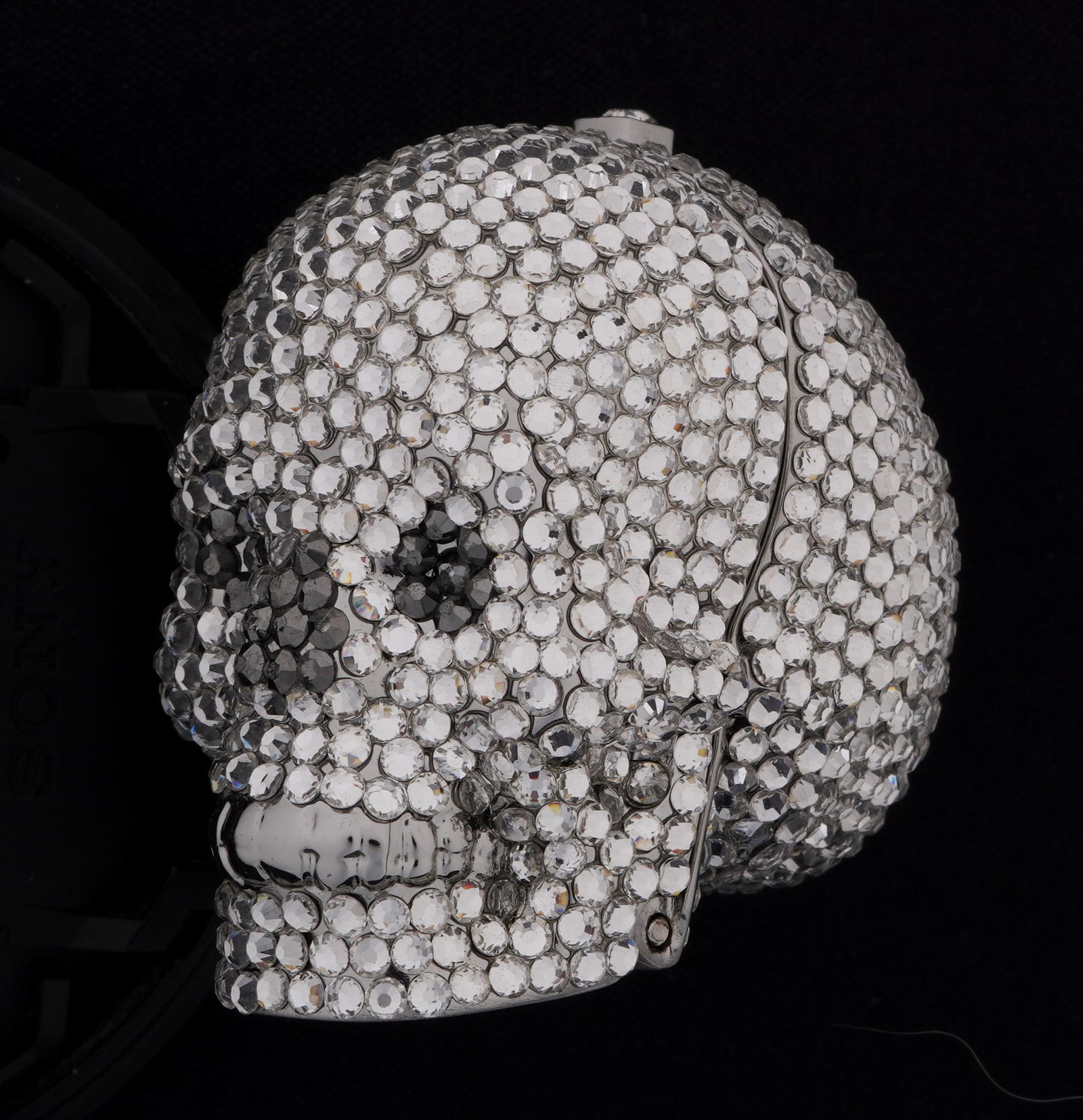 Judith Leiber Couture Crystal Skull Pillbox: Silver metal hinged skull form pillbox, beaded European crystals all over by Judith Leiber Couture. 1.5" h. x 1" x 1.5". Sold with authenticity card and original box. 2.5" x 5.5" x 3.75".