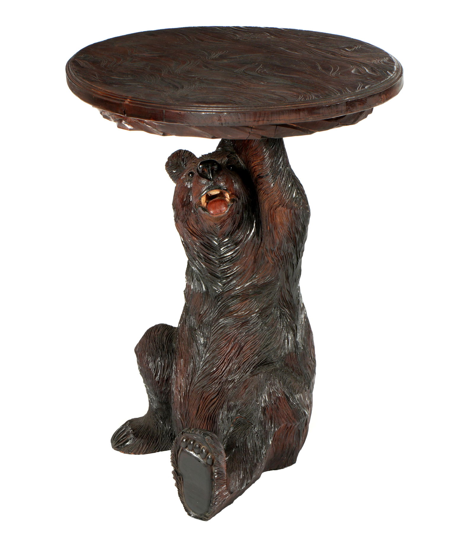 Black Forest Carved Bear Occasional Table: Oval stylized foliate motif top, nicely carved seated bear base, no visible markings. Overall 32" h. x 30.25" x 23.25". Condition: Minor wear.
