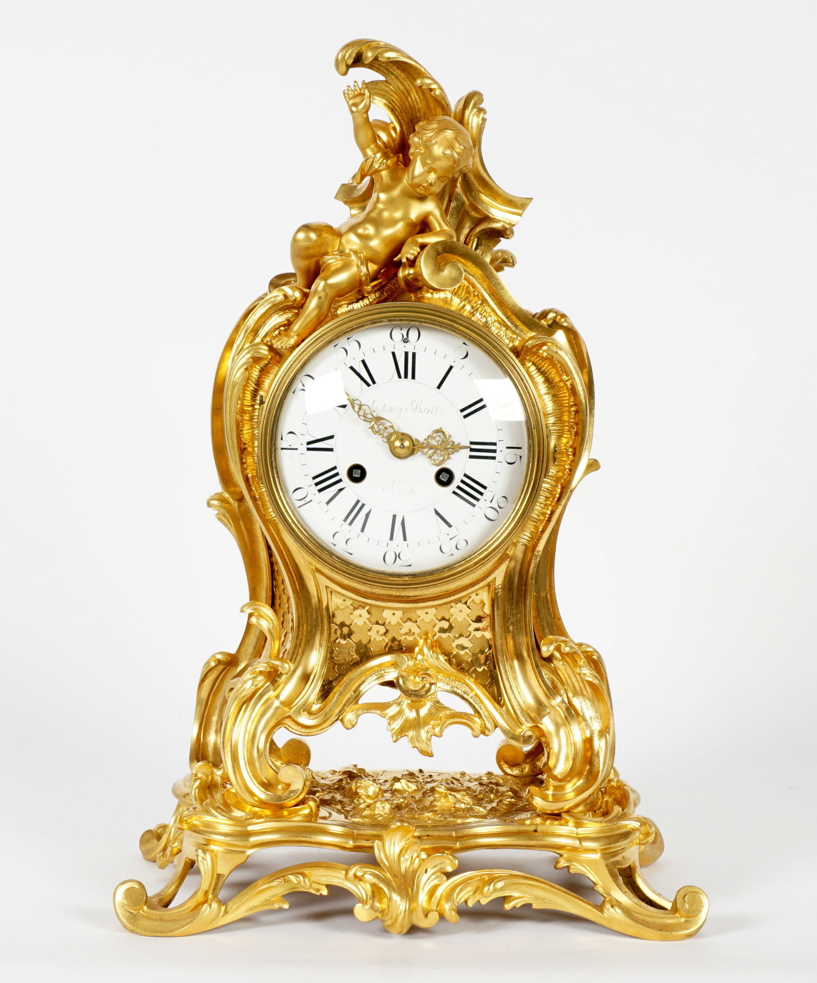 French Antony Bailly Figural Gilt Bronze Clock: 19th Century gilt bronze case with figural putti and foliate scroll motifs. Porcelain dial marked Antony Bailly, Lyon, roman and Arabic numerals. Unmarked French time and bell strike movement, replace