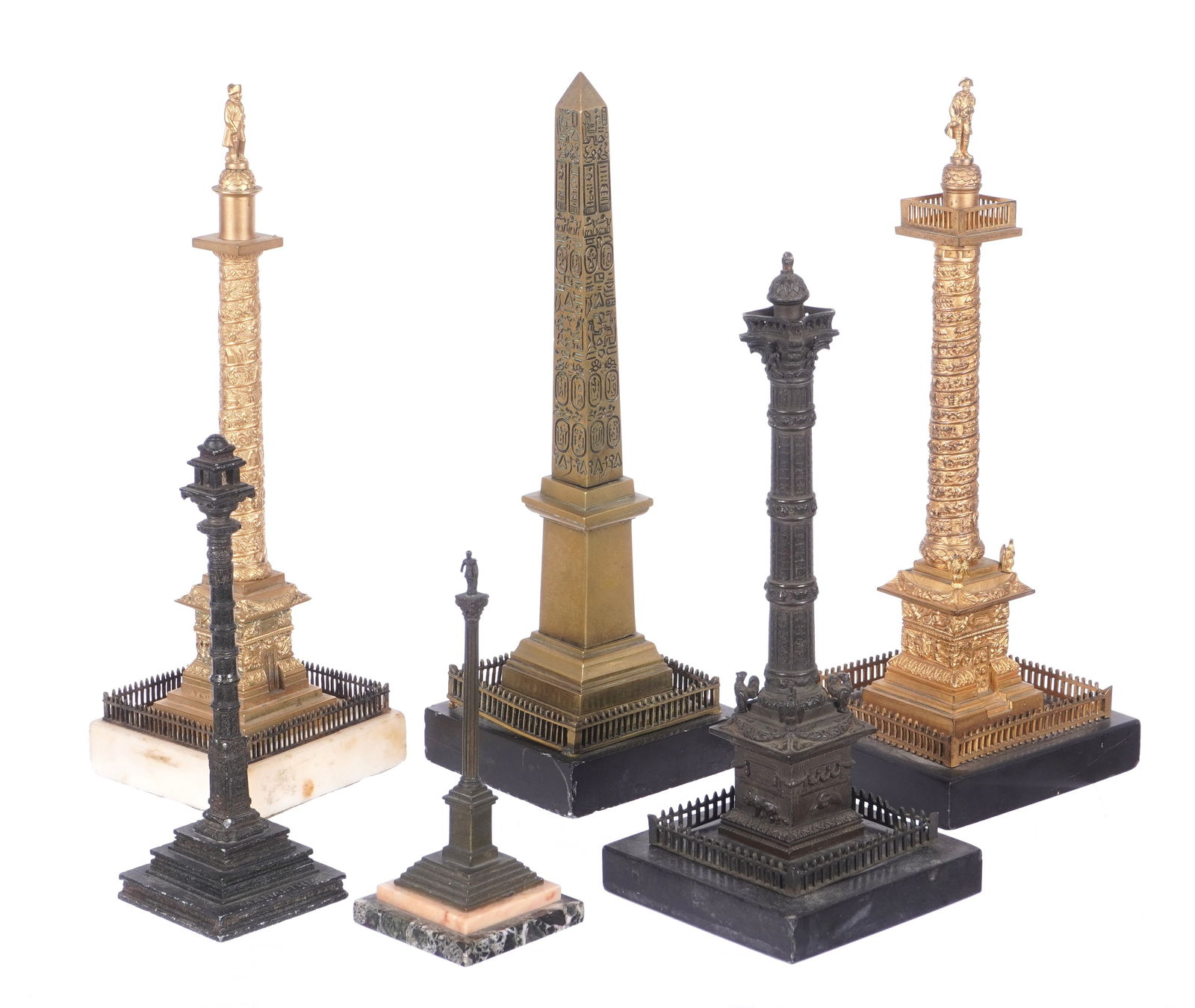 Six Grand Tour Obelisk and Column Sculptures: An assembled collection of six pieces total, each depicting a landmark column or obelisk, patinated or gilt bronze on stone bases. Tallest measures 10.75" h. x 4.25" x 4.25". Smallest 5.5" h.