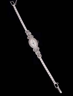 Waltham Ladies 14k gold & Diamond Wrist Watch: Oval 14mm x 20mm 14k white gold and accent diamond case, manual wind movement , ornate 14k white gold and diamond link