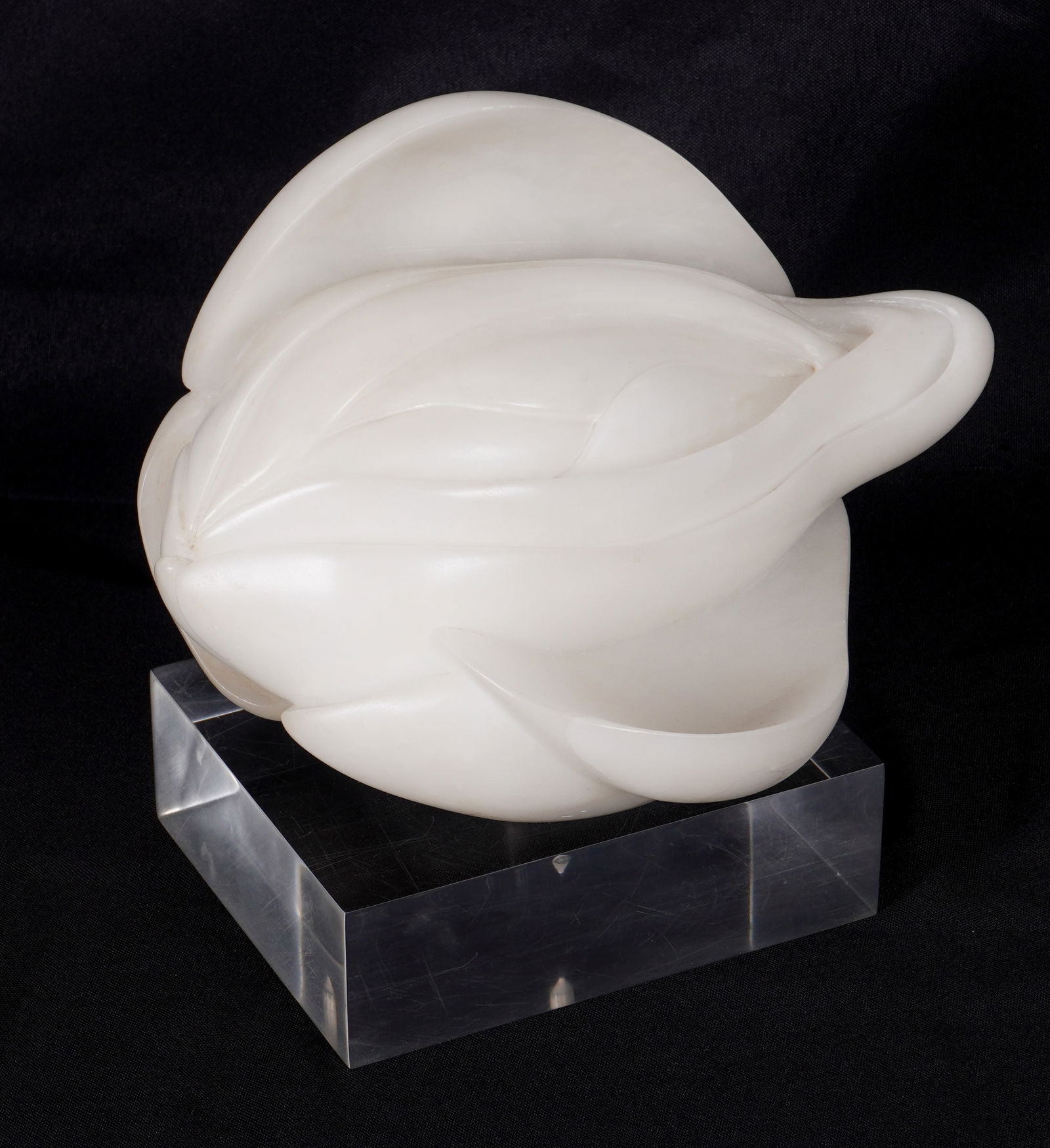 Modernist Carved Alabaster Erotic Flower Sculpture: Carved alabaster sculpture of an "erotic" flower, in the style of Georgia O'Keeffe unknown monogram signature underneath. Sculpture measures 6" h. x 9" x 6.5". Acrylic base, overall on base 9"h.