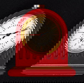 Bvlgari Travel Alarm Clock: Red enamel case, well marked on dial. Quartz movement, 2" h. x 1.75". Sold with a leather case. Needs battery, not running.