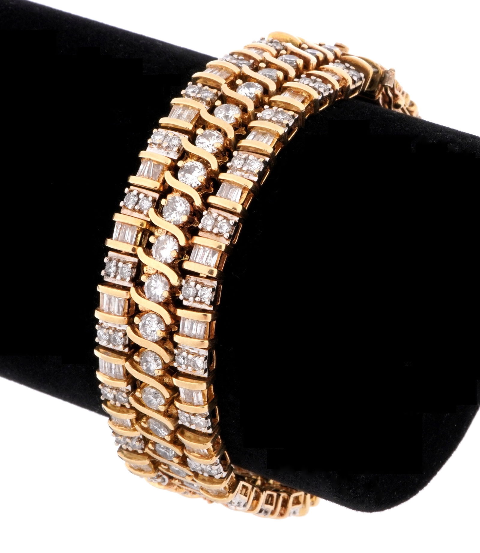 Triple Band 14k Gold and Diamond Tennis Bracelet: 14k yellow gold bracelet with three bands, center band with 38 prong set round brilliant diamonds, approx. 7.0ctw total. The two outer bands with alternating 2 prong set round and channel set baguette