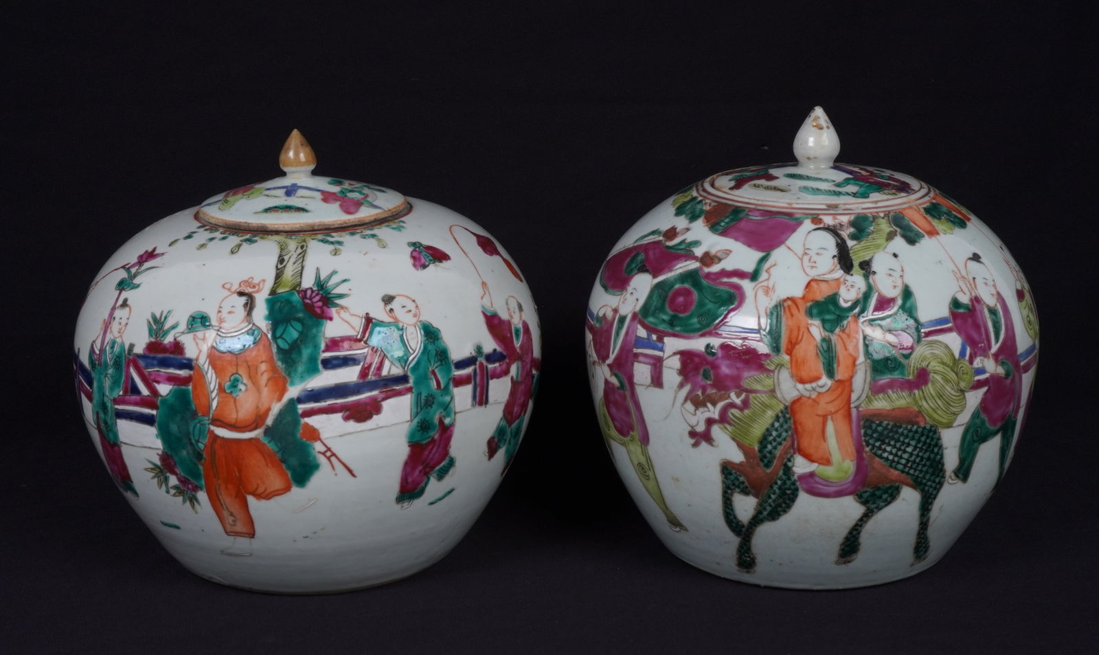 Two Chinese Famille Rose Porcelain Ginger Jars: Two lidded porcelain ginger jars total, each Famille Rose decorated with procession genre scenes with figures and stylized bats. Larger measures 9" h .x 8.5". Condition: Chips, minor wear to decoratio