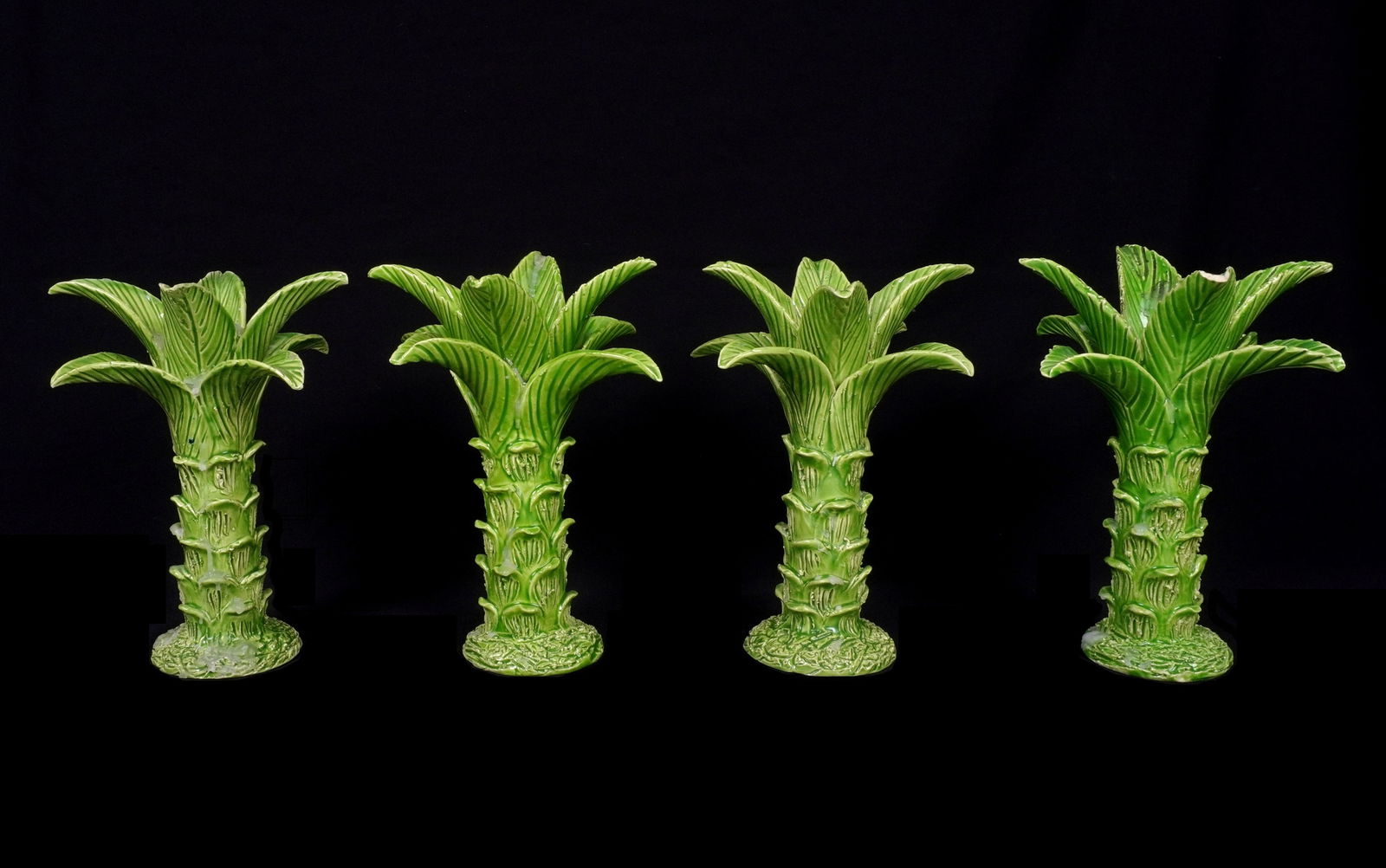 4 Jean Roger Paris Ceramic Palm Tree Candlesticks: Set of four green glazed ceramic palm tree form candlesticks, two signed Jean Roger, Paris. The other two signed JR, Made in France. 8" h. x 6". Condition: All with chips to palm fronds, one with repa