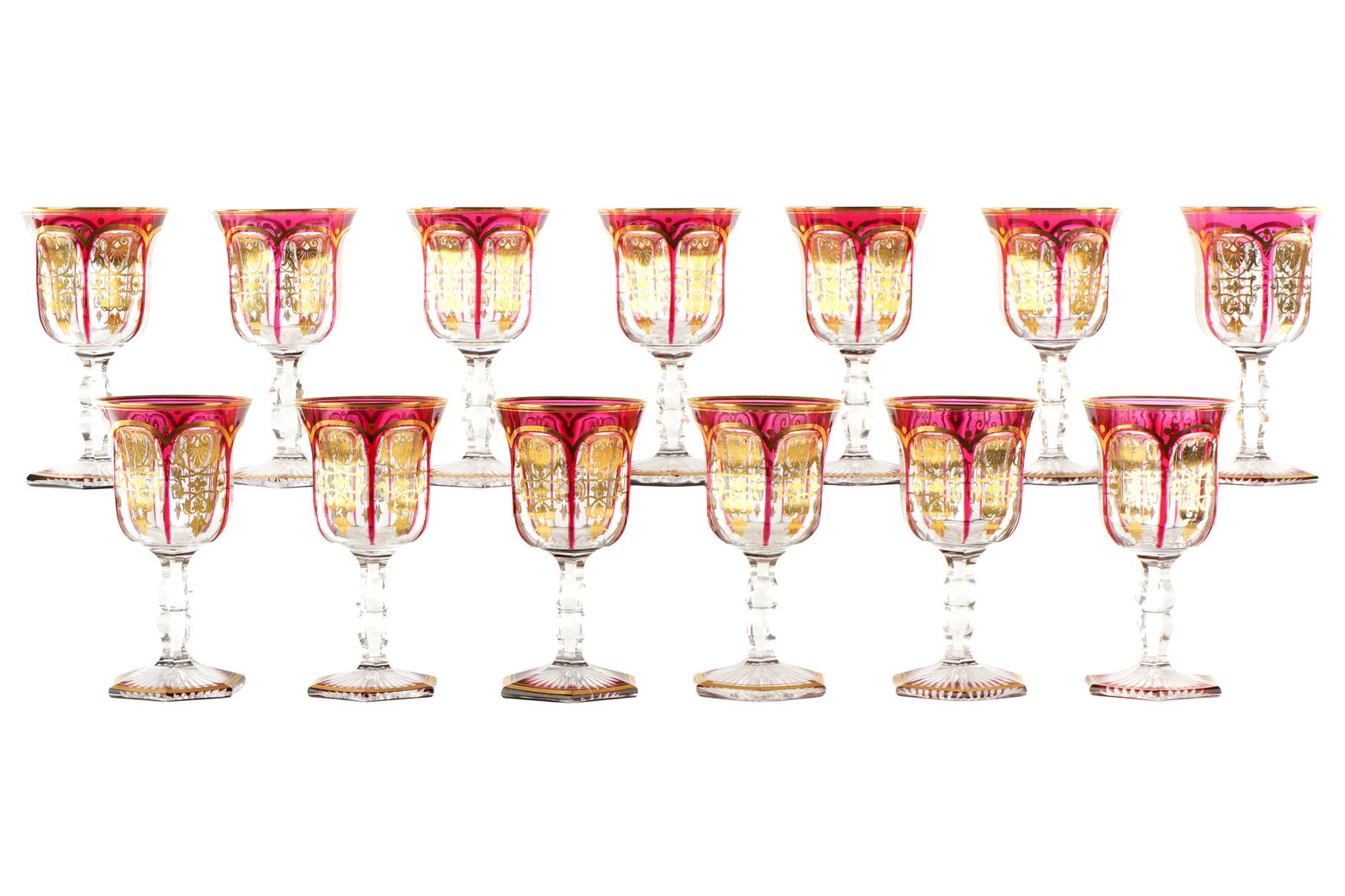 Set of 13 Baccarat Quality Empire Ruby Gilt Goblets: Bakers dozen set of 13 crystal water goblets in the "Empire" pattern by Baccarat or possible Moser. Unmarked. Ruby red overlay, gilt decoration in panels, faceted stem, starburst under foot. Overall 6