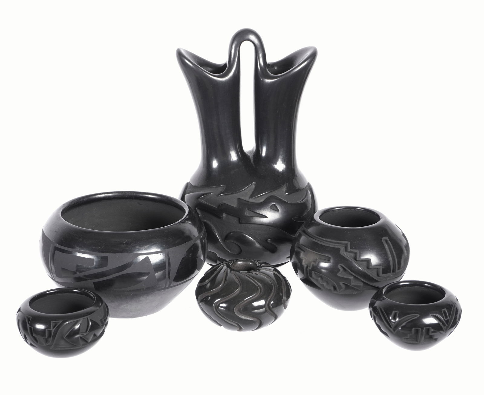 Six Piece Carved Santa Clara Pottery Blackware Vessels: An assembled collection of six pieces total to include 1) Linda Cain wedding vase, 9" h .x 5". 2) Maria and Santana Martinez bowl, 3.5" x 5.5". 3) Teresa Gutierrez bowl, 3.25" h. x 4". 4) Maria Suazo