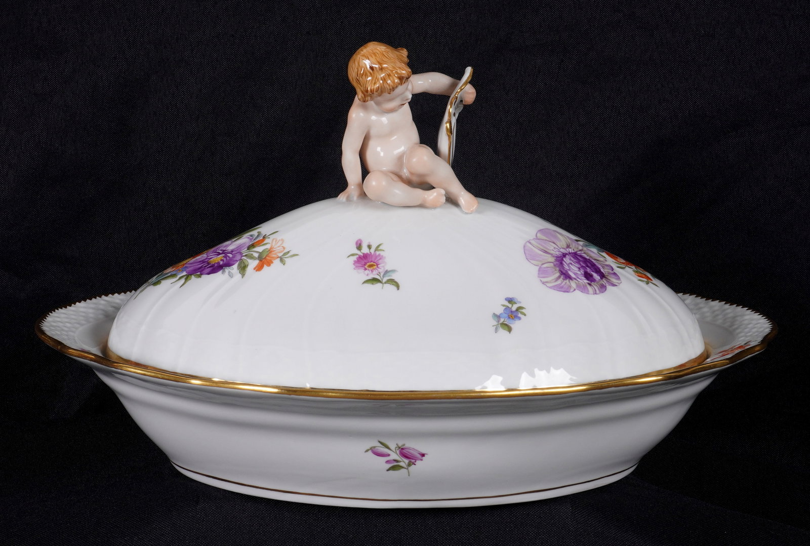 Royal Copenhagen Saxon Flowers Covered Vegetable: Oval covered vegetable dish in the Saxon Flowers pattern by Royal Copenhagen, Putti and shield finial on lid. Well marked. Overall 7" h. x 12.25" x 9.5".