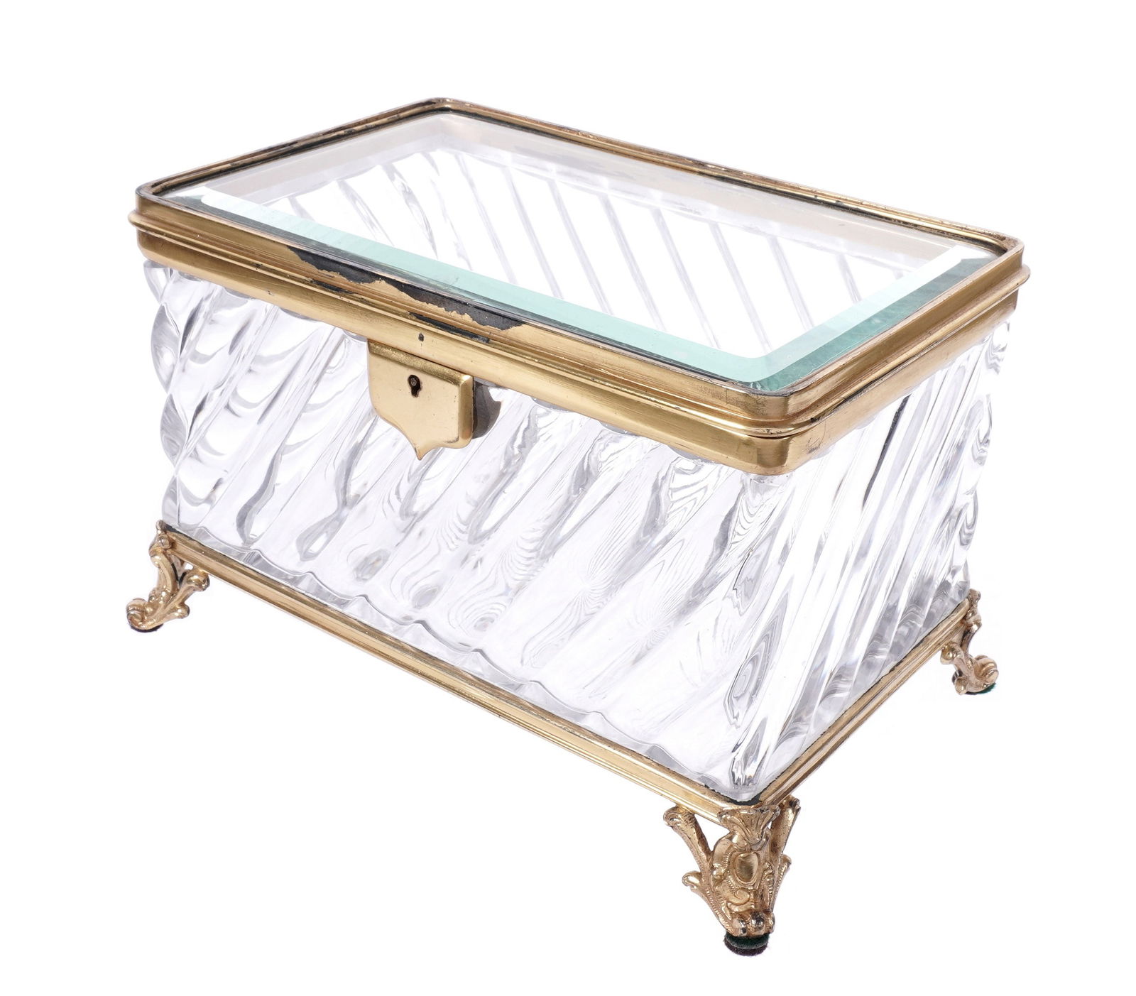 French Brass and Glass Jewelry Casket: Baccarat quality molded glass body, beveled glass hinged lid, gilt brass frame, all on four scroll feet. Unmarked, overall 5.75" h. x 9" x 5.75". Condition: Crack to bottom glass, wear to gilt finish.