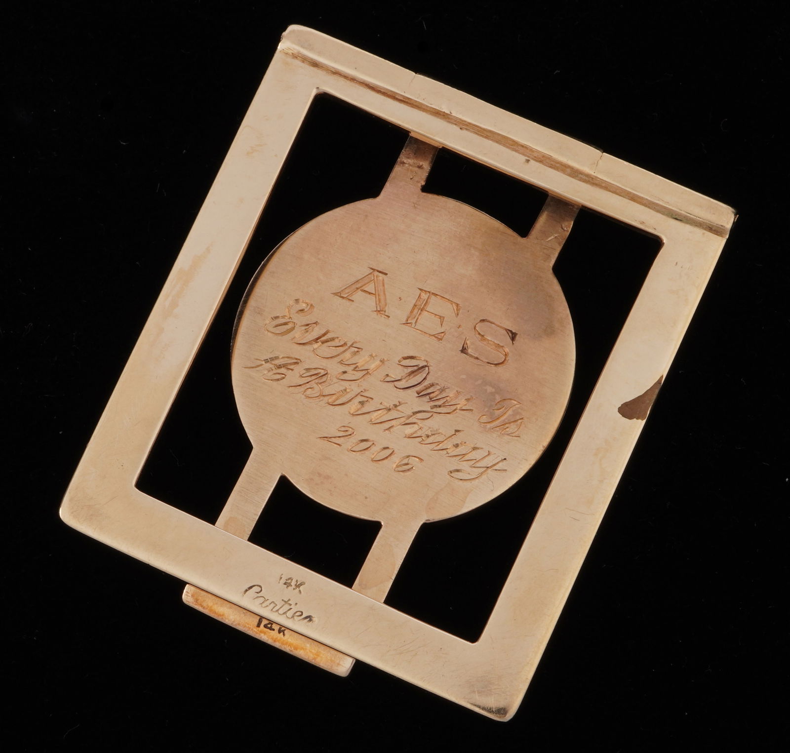 14k Gold Cartier Money Clip: 14k yellow gold money clip by Cartier, dedication on front and initials on back, 1.75" x 1.5". Approx. 35 grams. Condition: Note discoloration spot on one side.