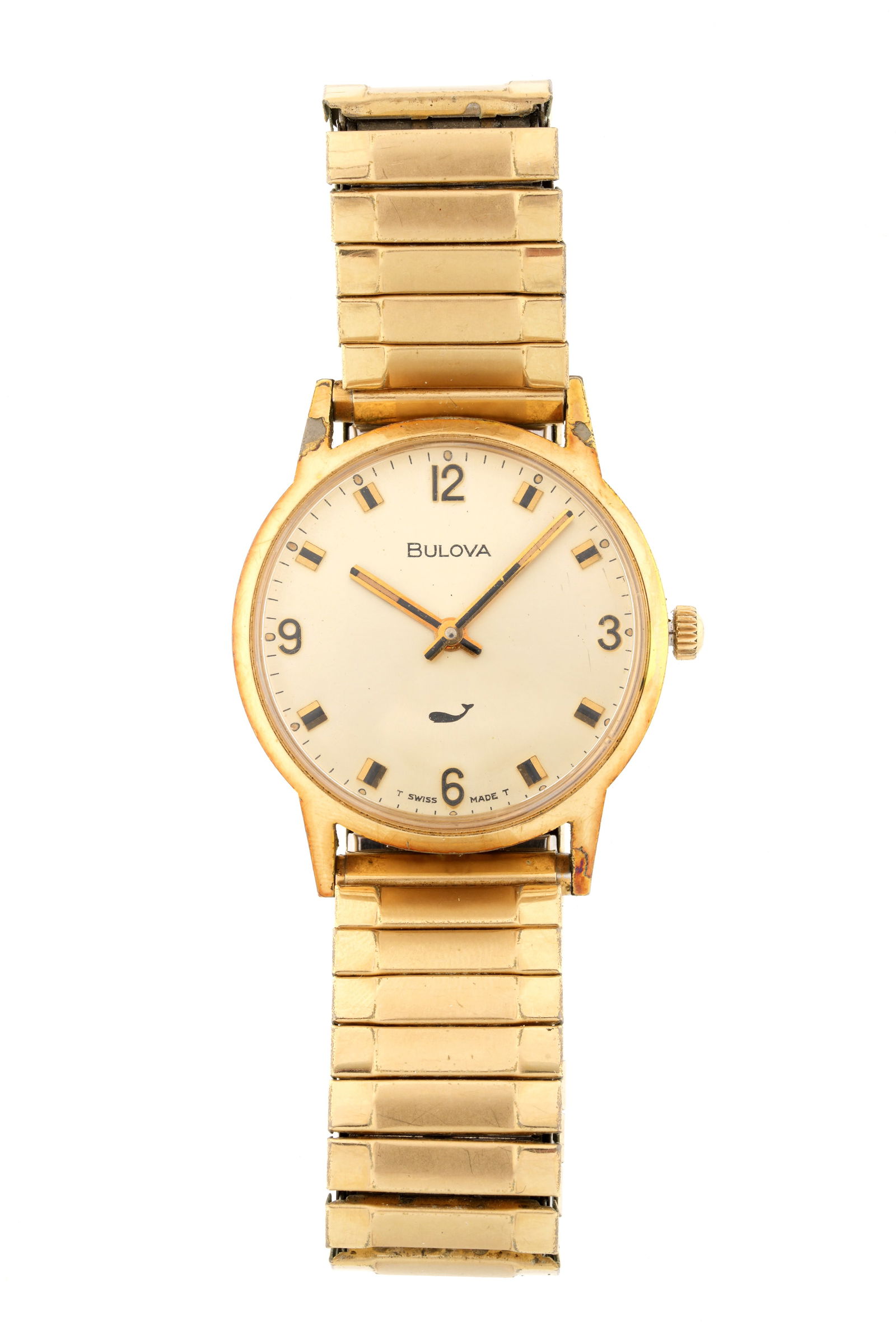 Vintage Bulova Gold Toned Wrist Watch: 30mm stainless steel case with gold plated bezel, manual wind movement, gold toned dial with whale logo, stretch gold toned band, Condition: Minor signs of wear. Currently running however not guarante