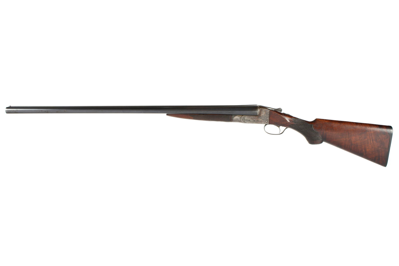 Ithaca 12 Gauge Double Barrel Shotgun: Serial number 287955, hammerless single trigger side by side, ornate engraved receiver, barrel length 30", 13.5" length to pull, checkered walnut stock, overall 46.25". Condition: surface spotting and