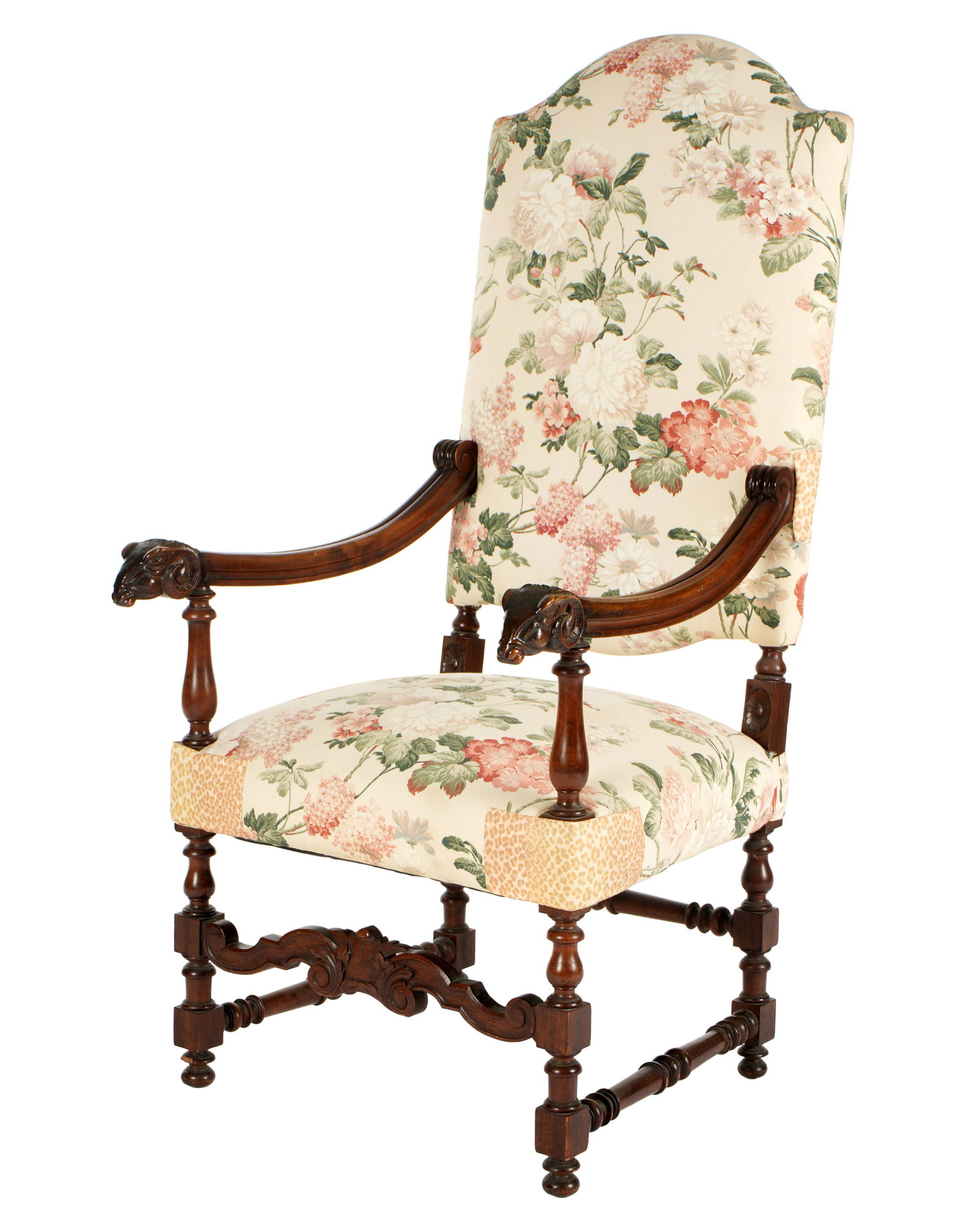 French Carved Walnut Upholstered Arm Chair: Carved and shaped walnut frame, shaped arms ending in rams head hand holds, turned arm supports. Serpentine foliate scroll front stretcher, turned legs. Floral upholstery, overall 54.5" h. x 26" x 28"
