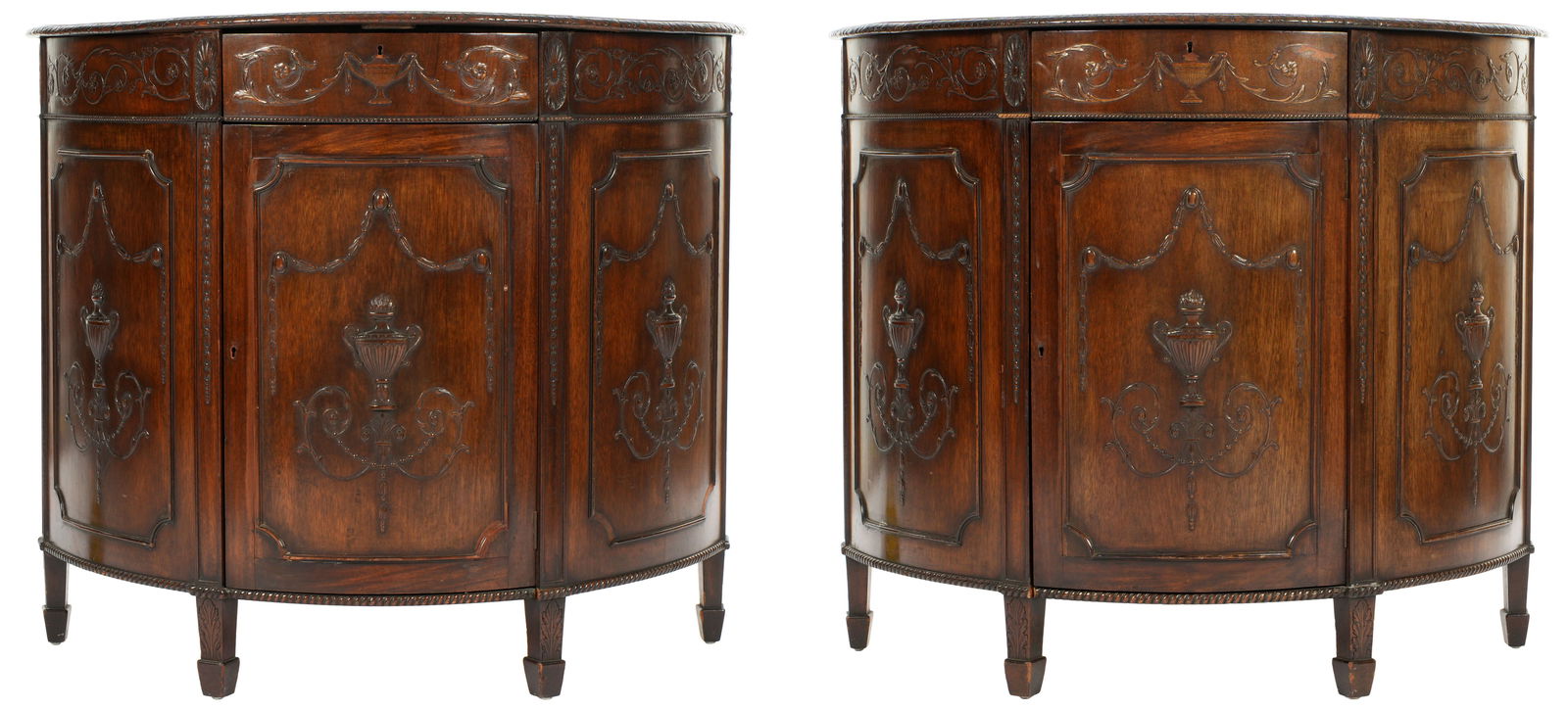 Pair Adams Style English Carved Demilune Chests: Late 19th / early 20th Century carved mahogany demilune commodes in the Adams style. Demilune tops with carved trim over conforming case with single drawer over single door with single interior
