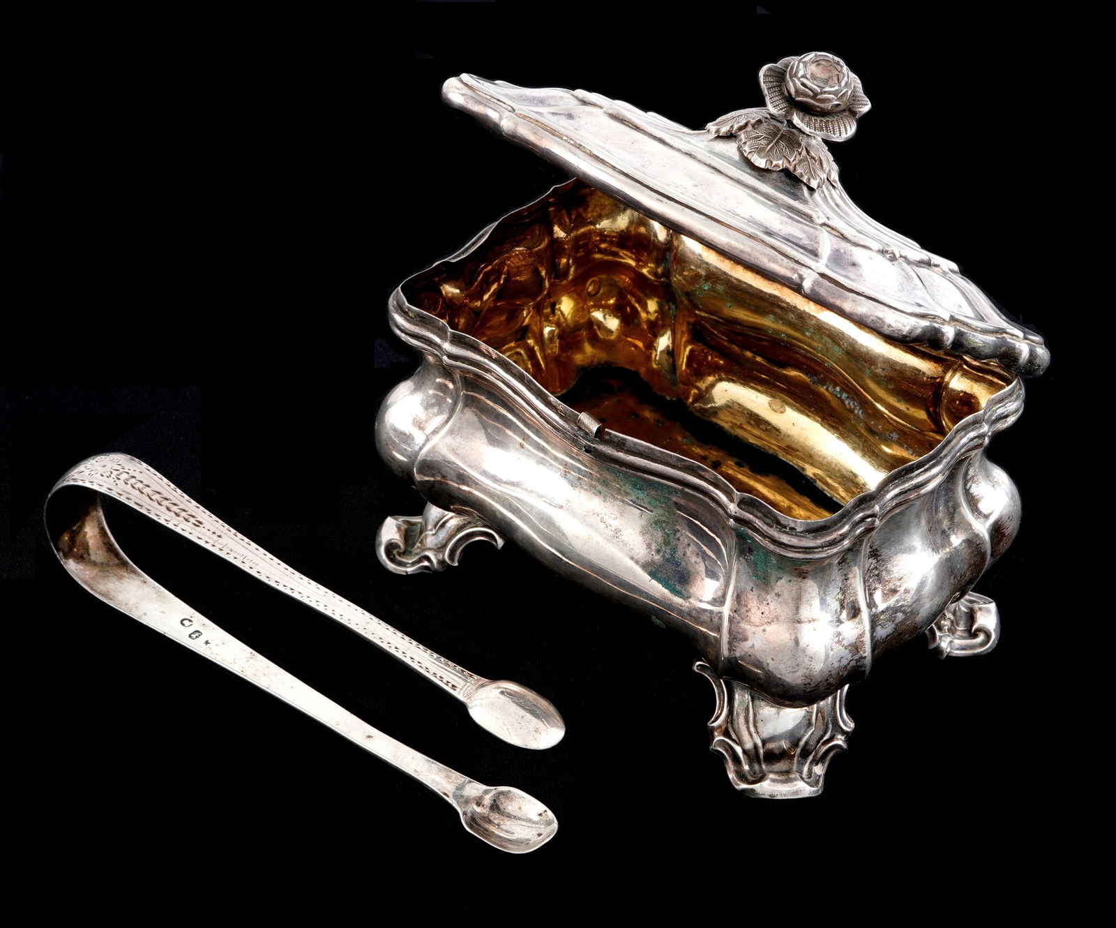 Austrian Empire Silver Sugar Box and Tongs: .812 Austrian silver sugar box, hinged lid with rose finial, lobed form body, on four scroll feet. 13 loth mark on back, overall 4.5" h .x 5" x 3". Sold with unassociated set of English sterling