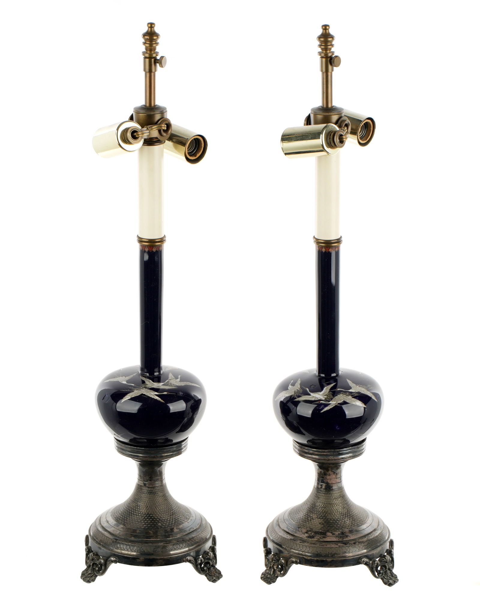 Pair Japanese Crane Cloisonne Bottle Lamps: Deep blue enamel vases with elongated bottle necks, cloisonne enamel cranes in flight on shoulders. French silverplate bases stamped A. Boulenger, double socket fixtures. Overall 19.5" h. x 5" dia.