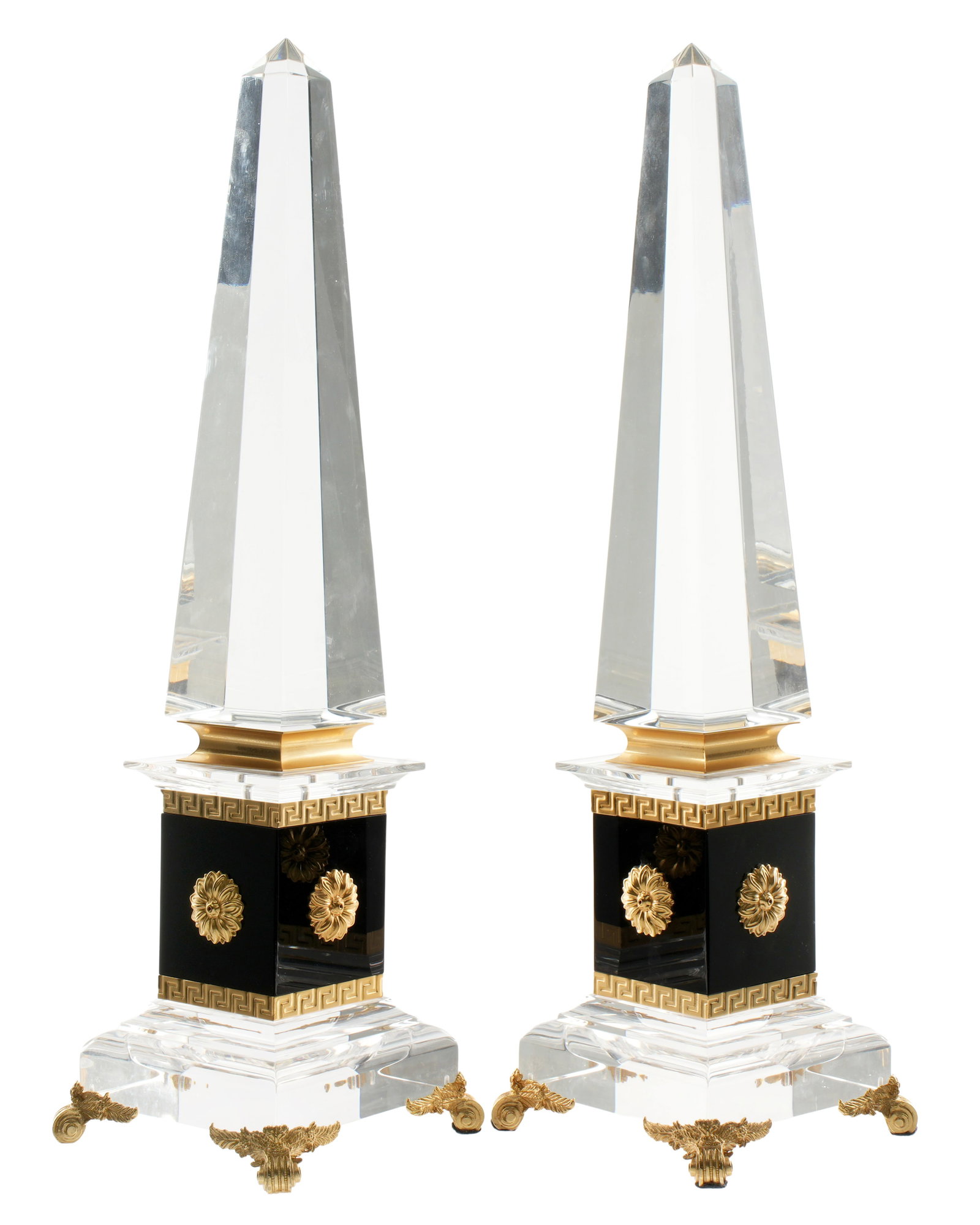 Pair Empire Style Lucite and Brass Obelisks: Matched pair, clear Lucite / acrylic top. brass and black enameled supports with floral medallions, Lucite base, four brass scroll feet. Overall 21.5" h .x 6.25" x 6.25". Condition: One slightly loose