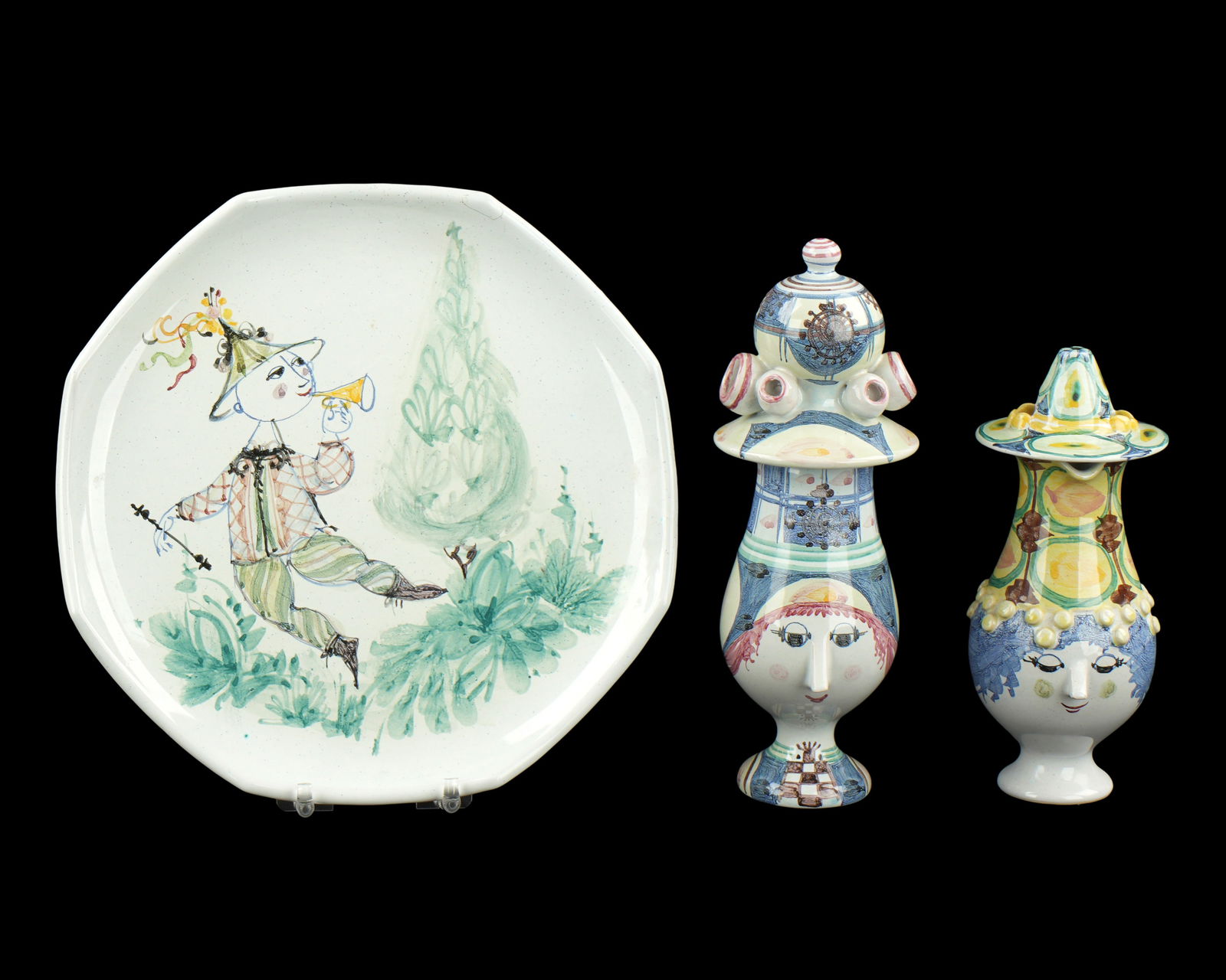 Bjorn Wiinblad Denmark Two Creamers and a Plate: Three polychrome decorated ceramic pieces total, each signed, to include 1) Figural cream pitcher, 6.75" h. x 5.25". Note chips to nose. 2) Covered figural cream pitcher, 10.5" h. x 5". Note repairs t