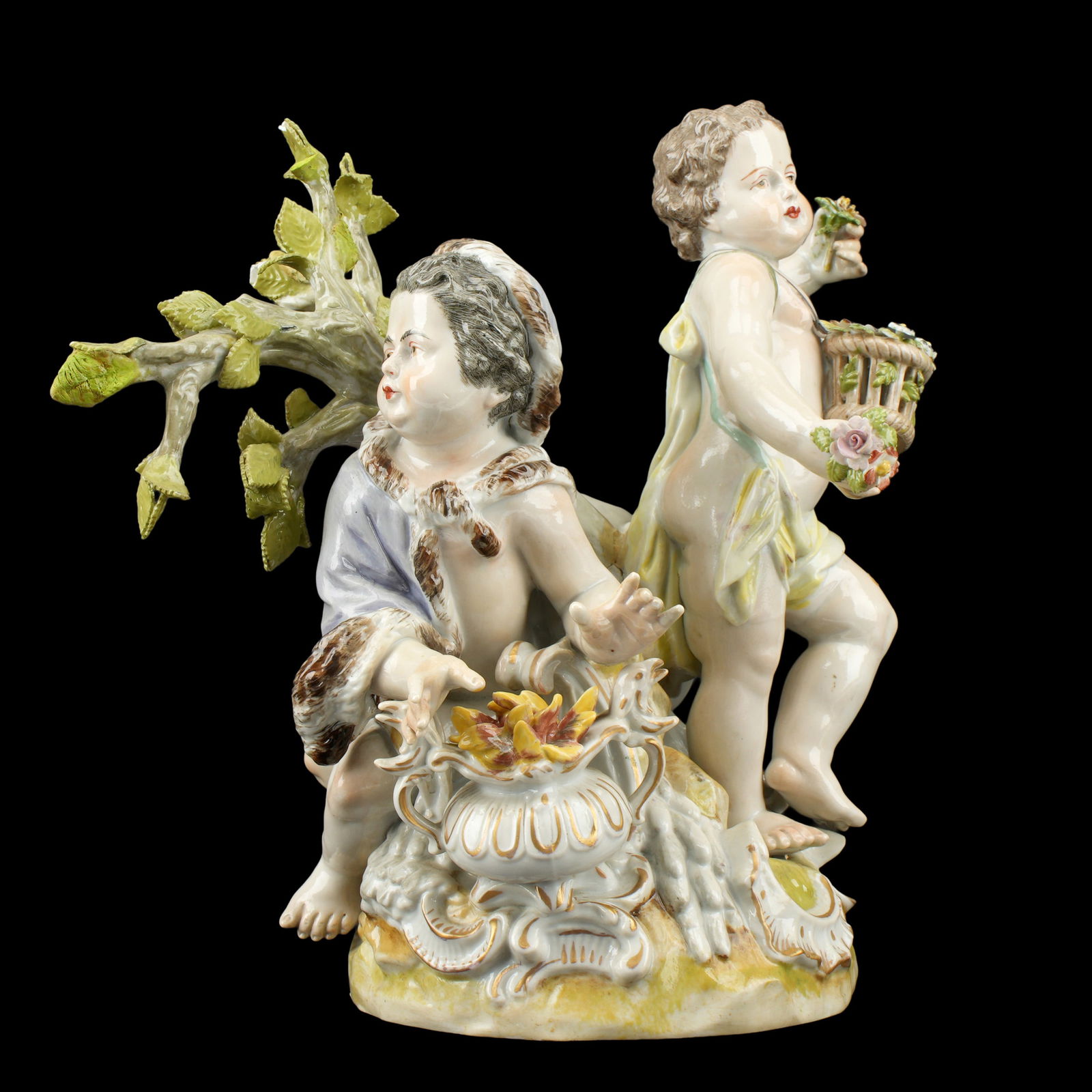 Carl Thieme Dresden Porcelain Figural Group: Porcelain figural group depicting allegorical Summer and Winter putti with tree. Well marked under foot, overall 9.5" h. x 10.75" x 6.5". Condition: Several repairs and chips to leaves.